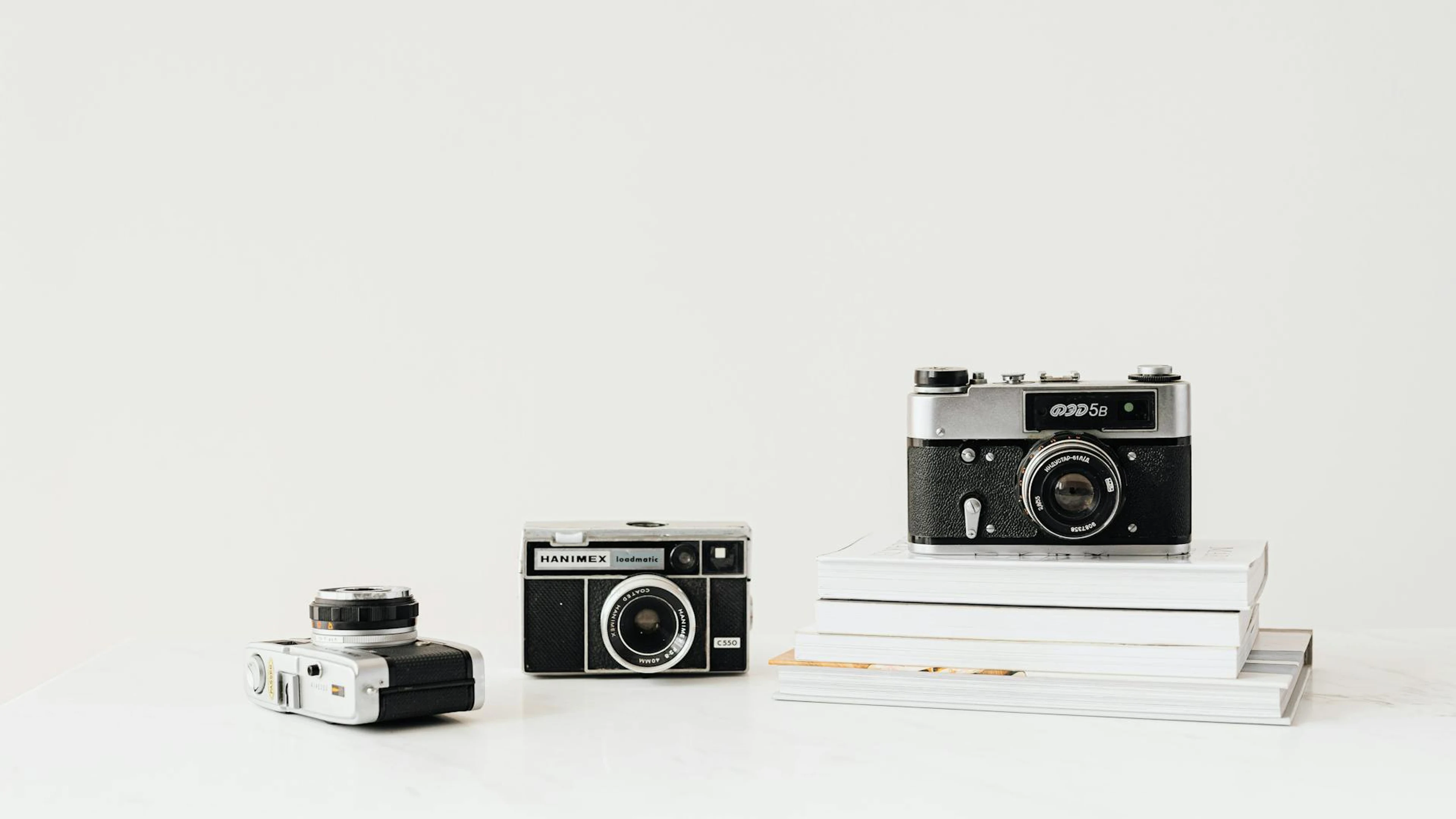 Three vintage cameras displayed on a white background, emphasizing nostalgia and - free 4K Ultra HD aesthetic wallpaper for desktop