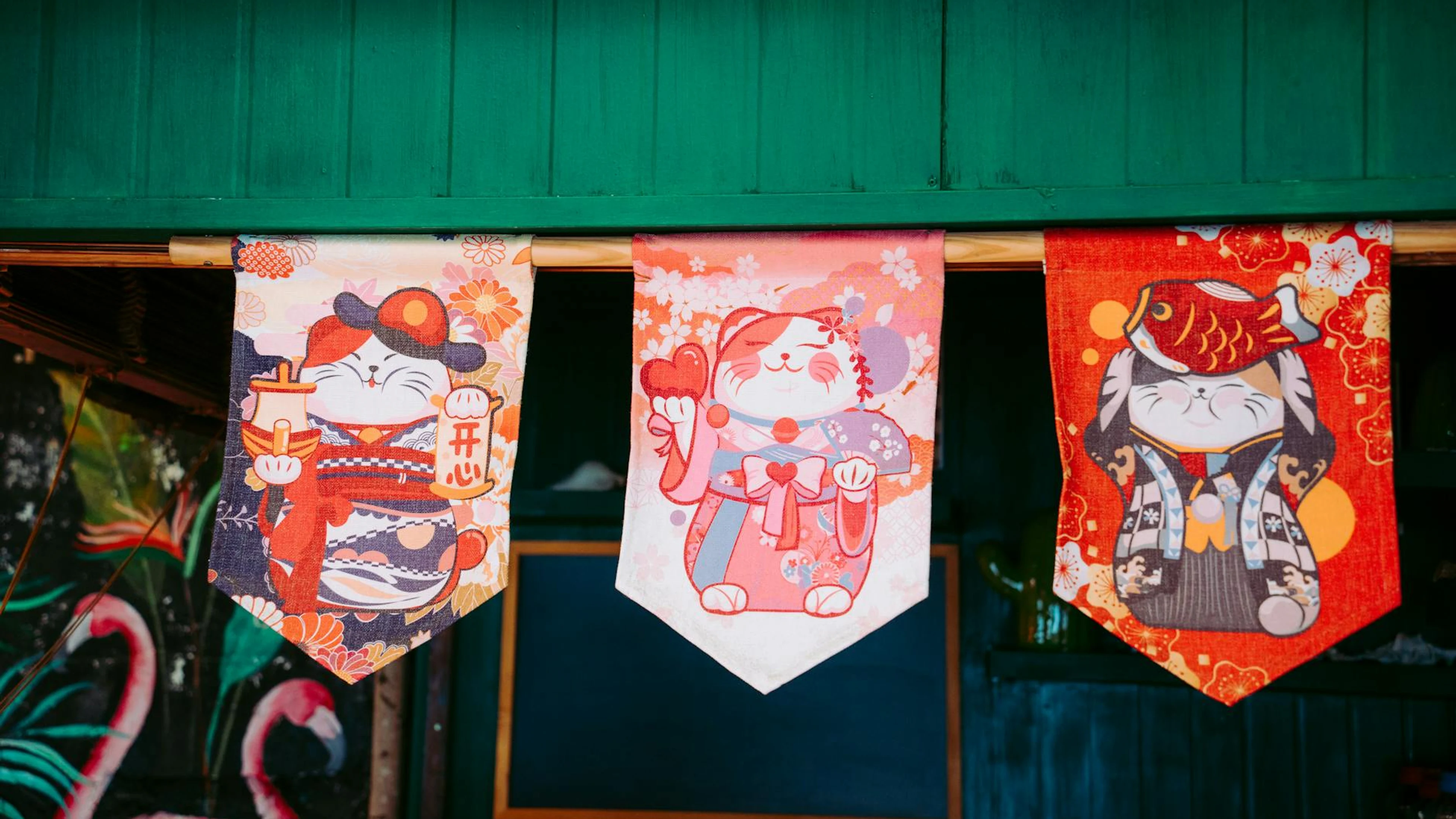 Vibrant Japanese Maneki-neko banners with floral patterns hanging indoors, creat - free 4K Ultra HD anime wallpaper for desktop