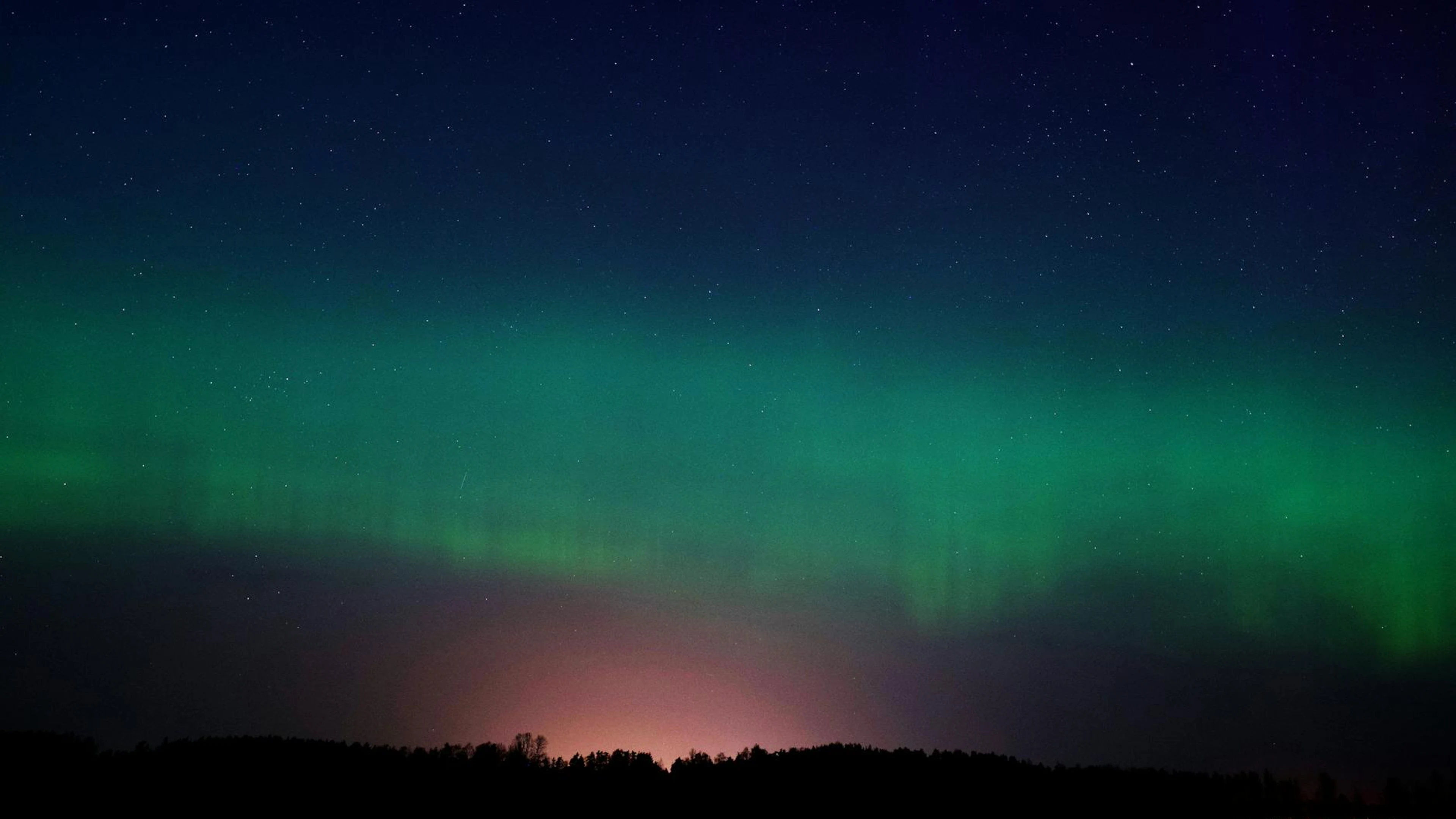 A mesmerizing display of the Aurora Borealis in the night sky over Ventspils, La - free 4K Ultra HD aurora wallpaper for desktop