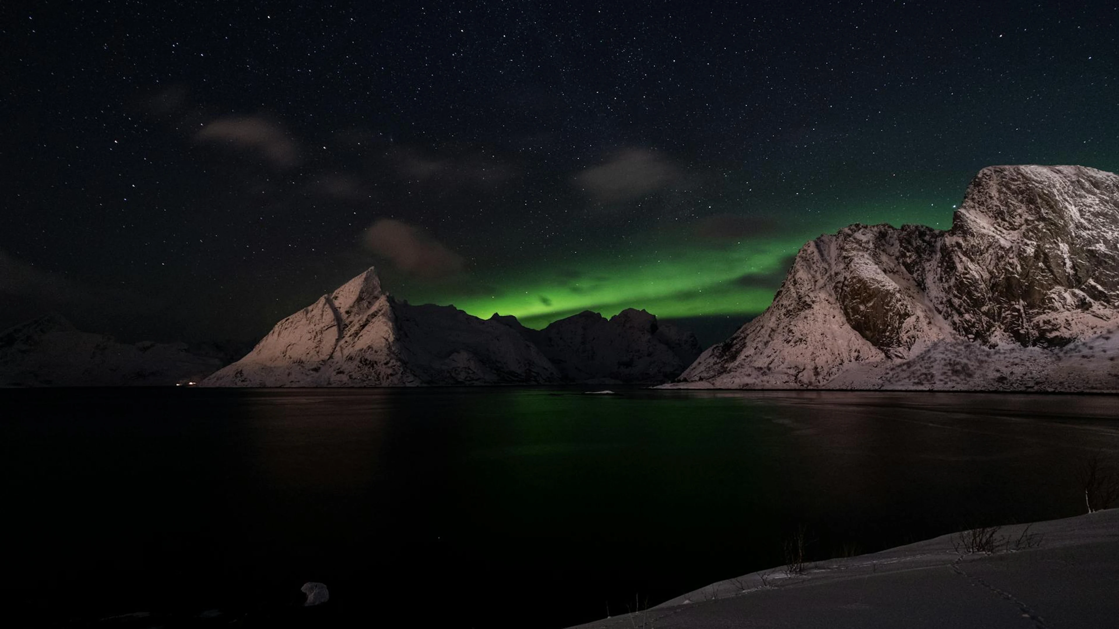 Captivating view of northern lights dancing above snow-covered mountains during - free 4K Ultra HD aurora wallpaper for desktop