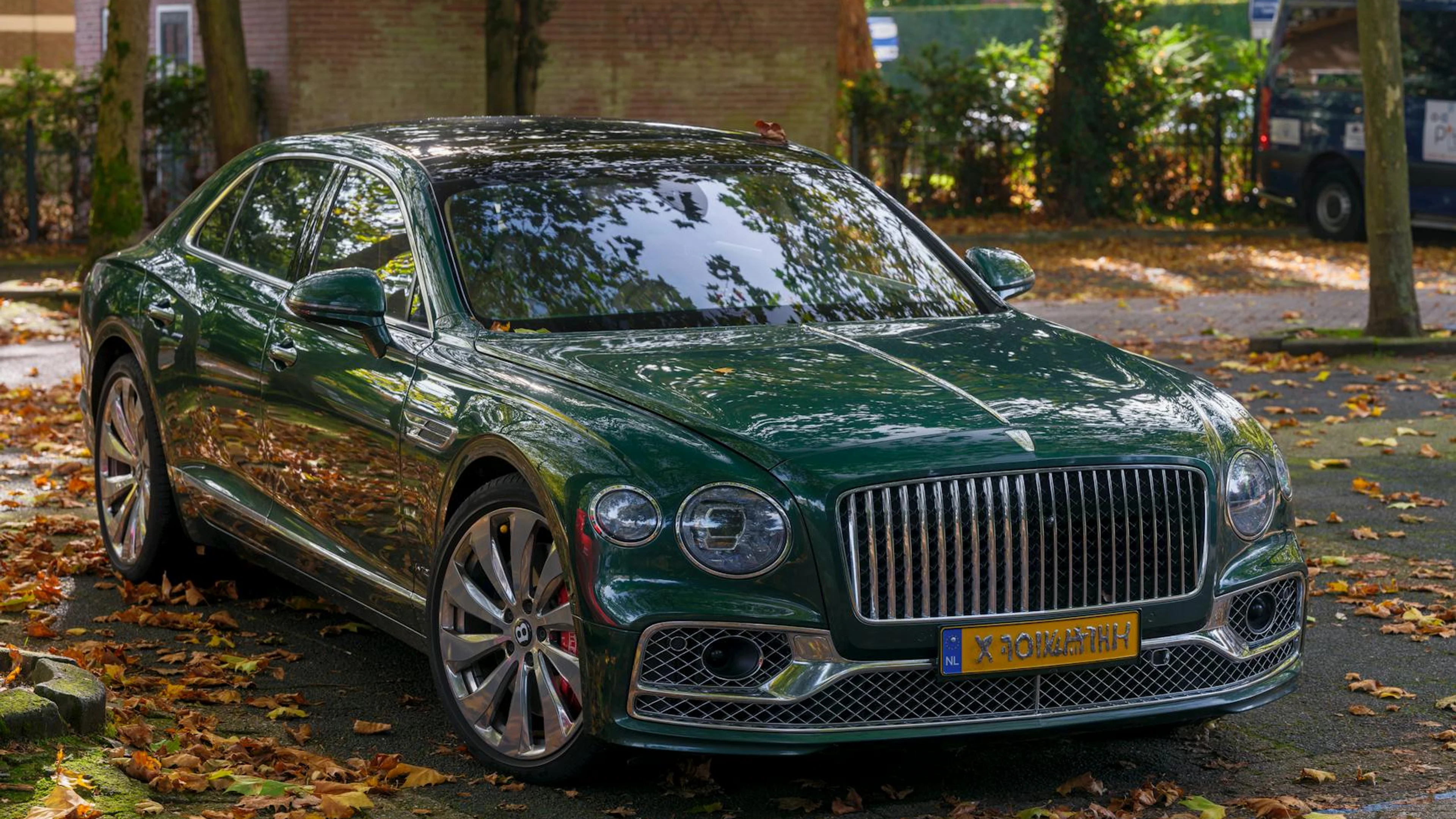 A luxurious Bentley parked on a leafy street, showcasing autumn's charm and eleg - free 4K Ultra HD cars wallpaper for desktop