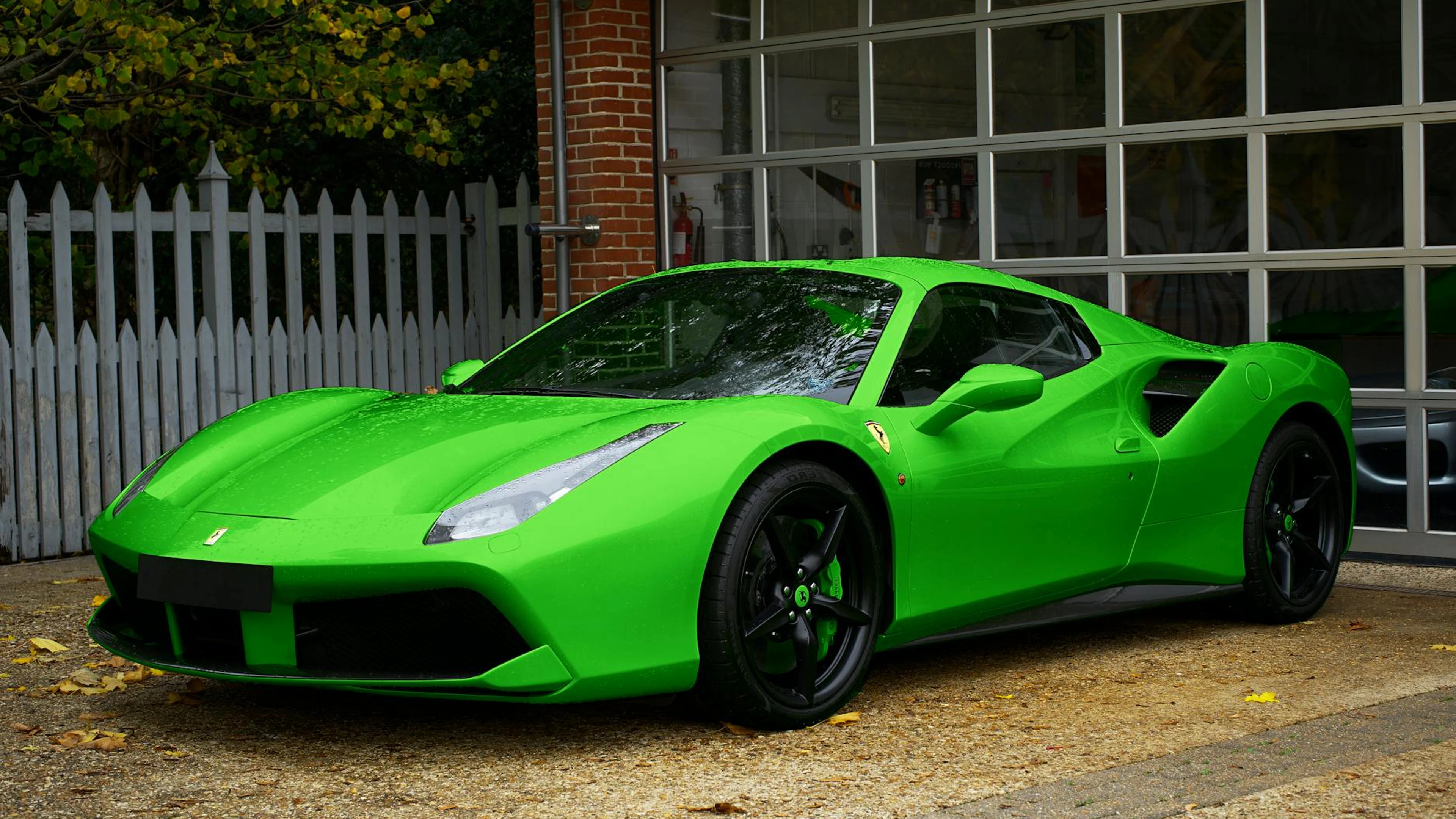 A striking green sports car parked in front of a garage with a glass facade and - free 4K Ultra HD cars wallpaper for desktop