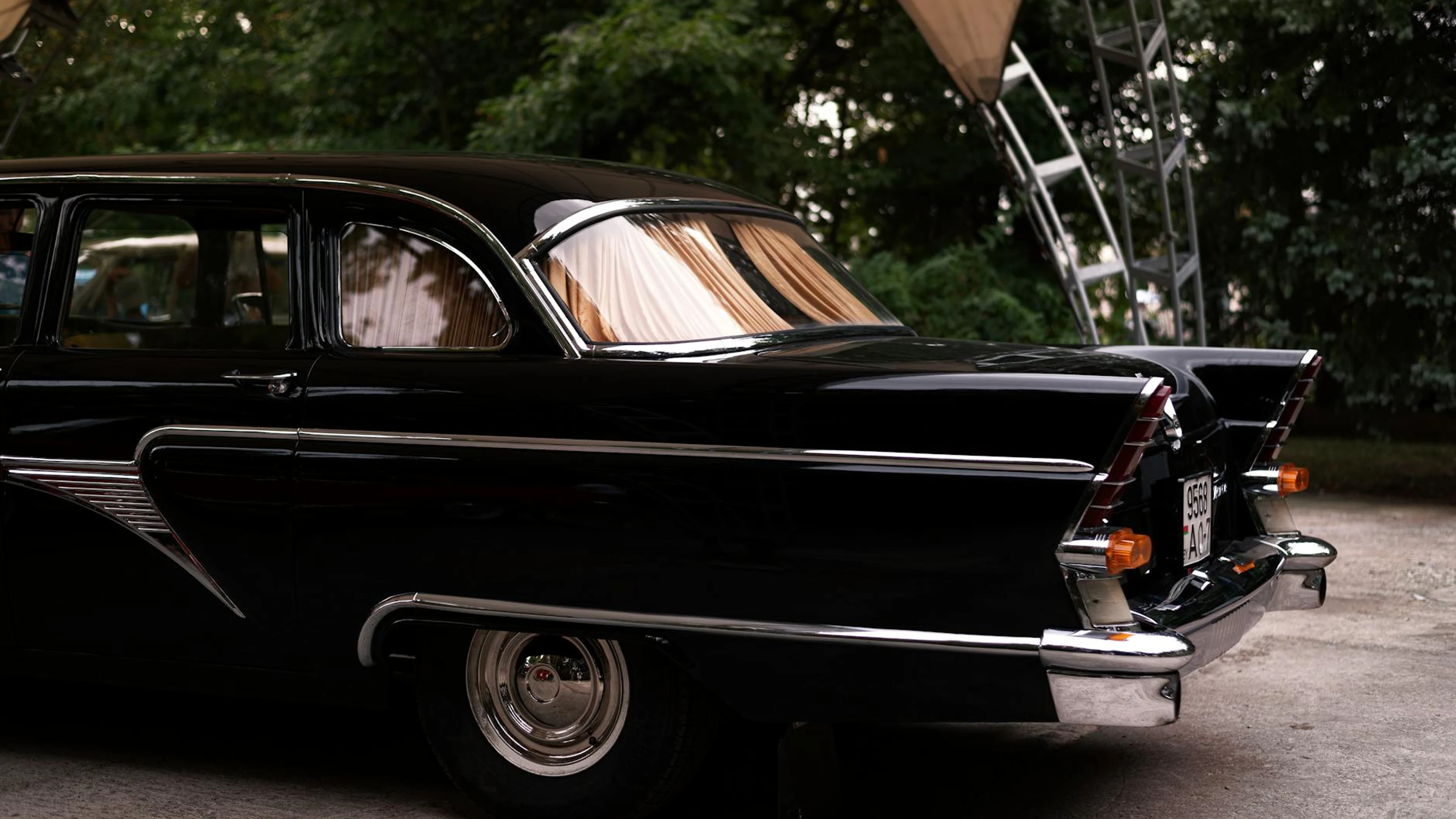 Classic vintage black car parked under a canopy in an outdoor setting. - free 4K Ultra HD cars wallpaper for desktop