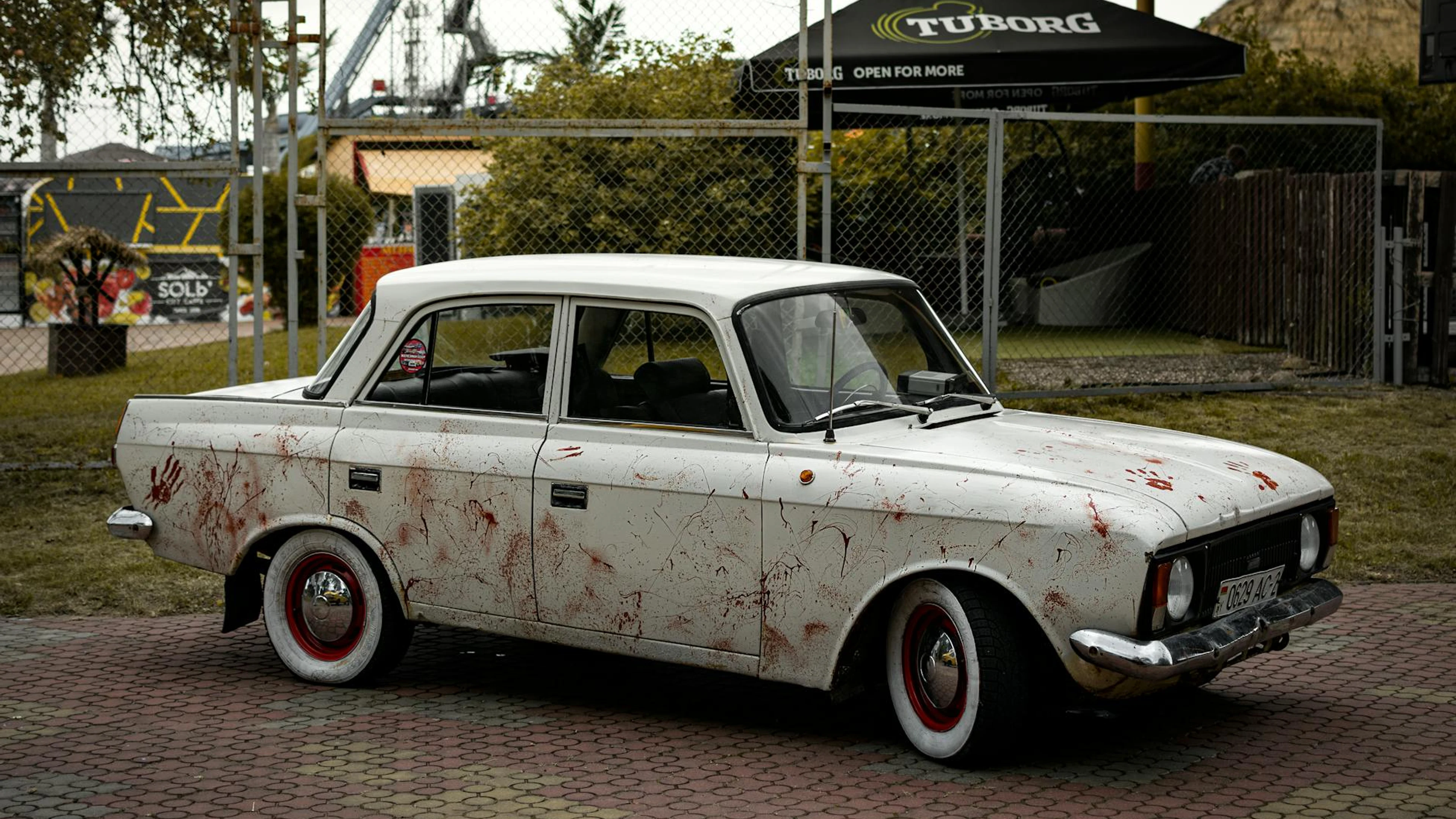Classic white car with mysterious red marks, parked outdoors in Minsk, Belarus. - free 4K Ultra HD cars wallpaper for desktop