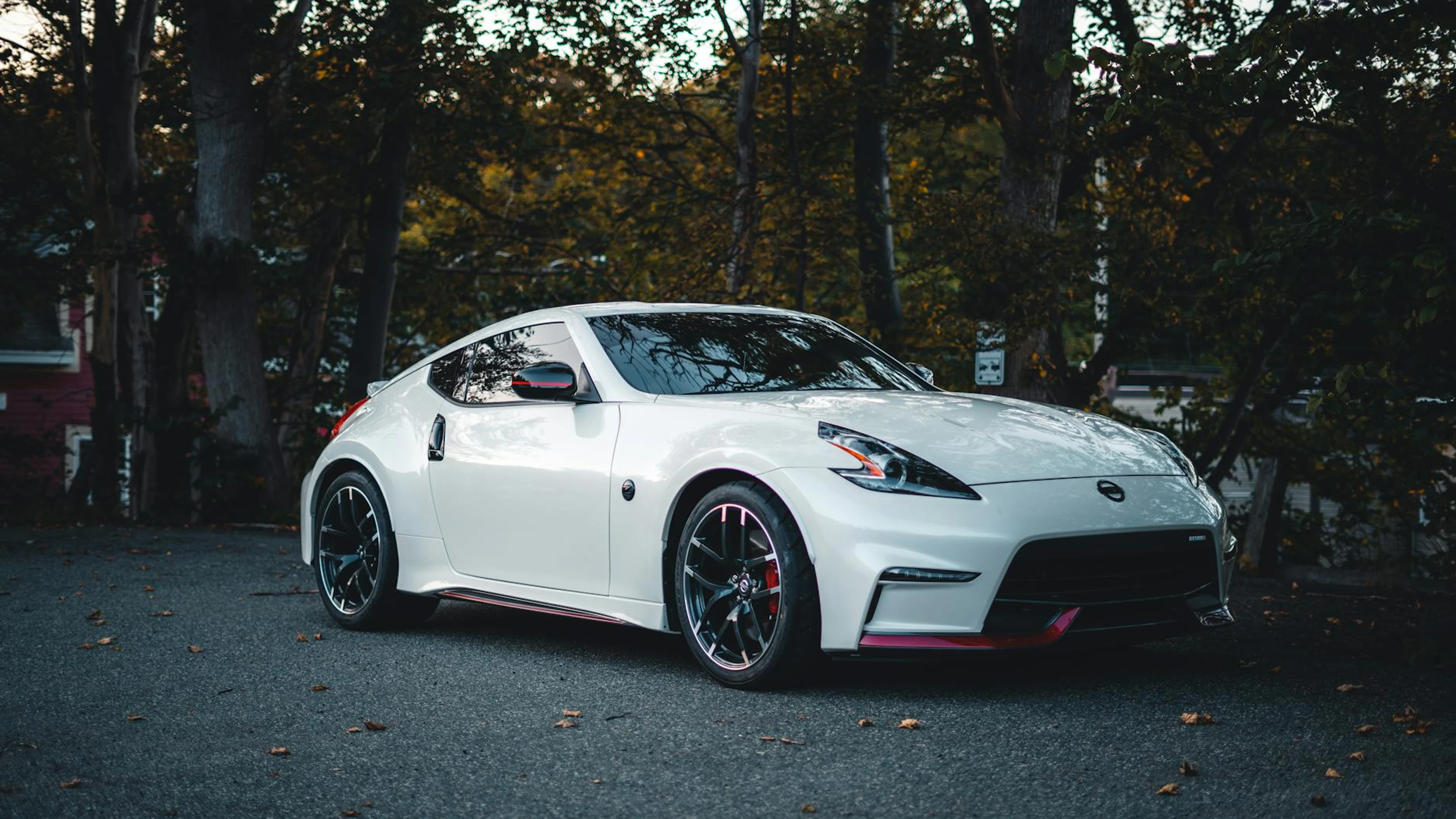 Elegant white Nissan sports car parked on a forest road during autumn. - free 4K Ultra HD cars wallpaper for desktop