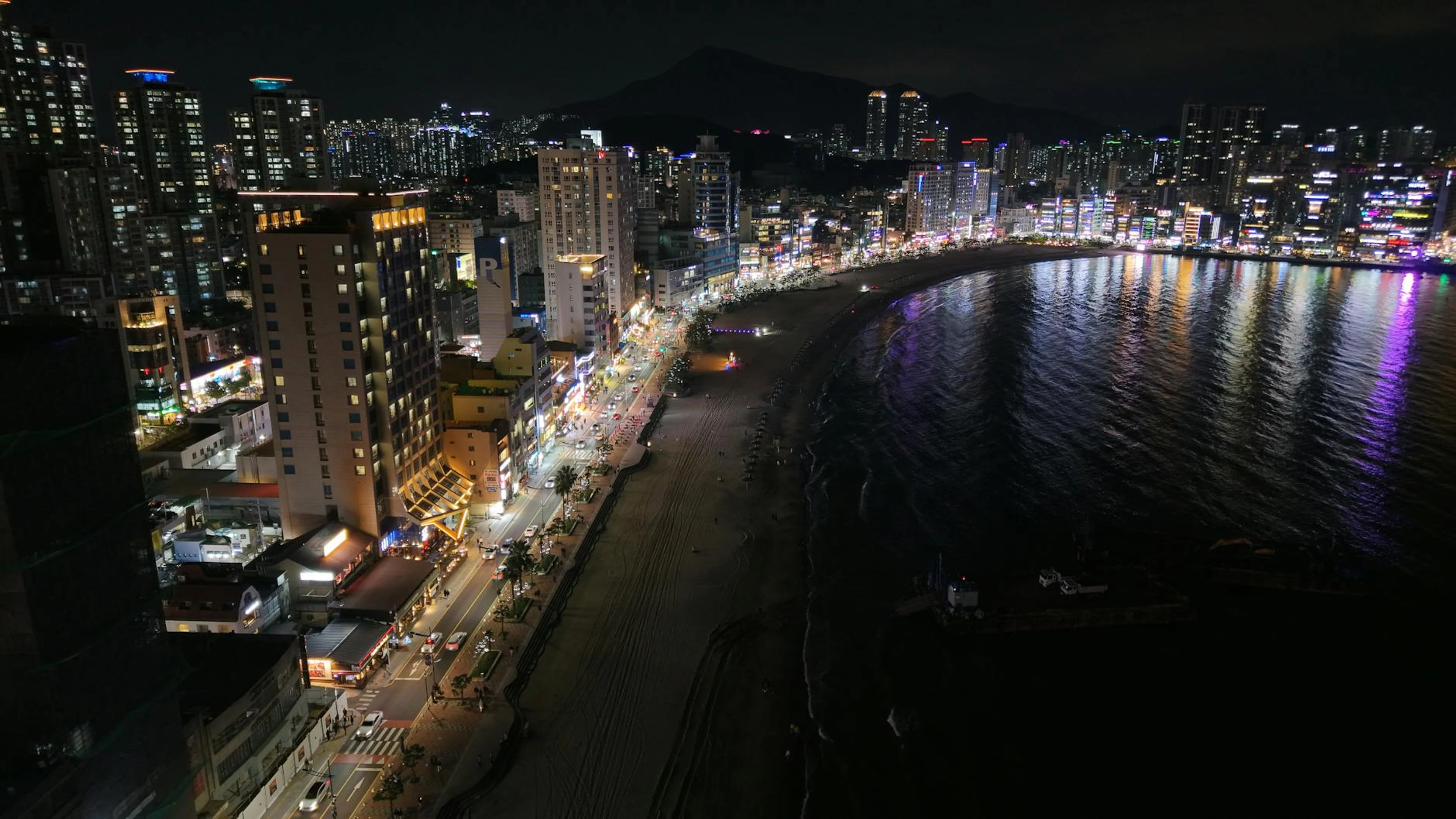 Stunning night view of Busan's skyline and beach, showcasing vibrant city lights - free 4K Ultra HD city wallpaper for desktop