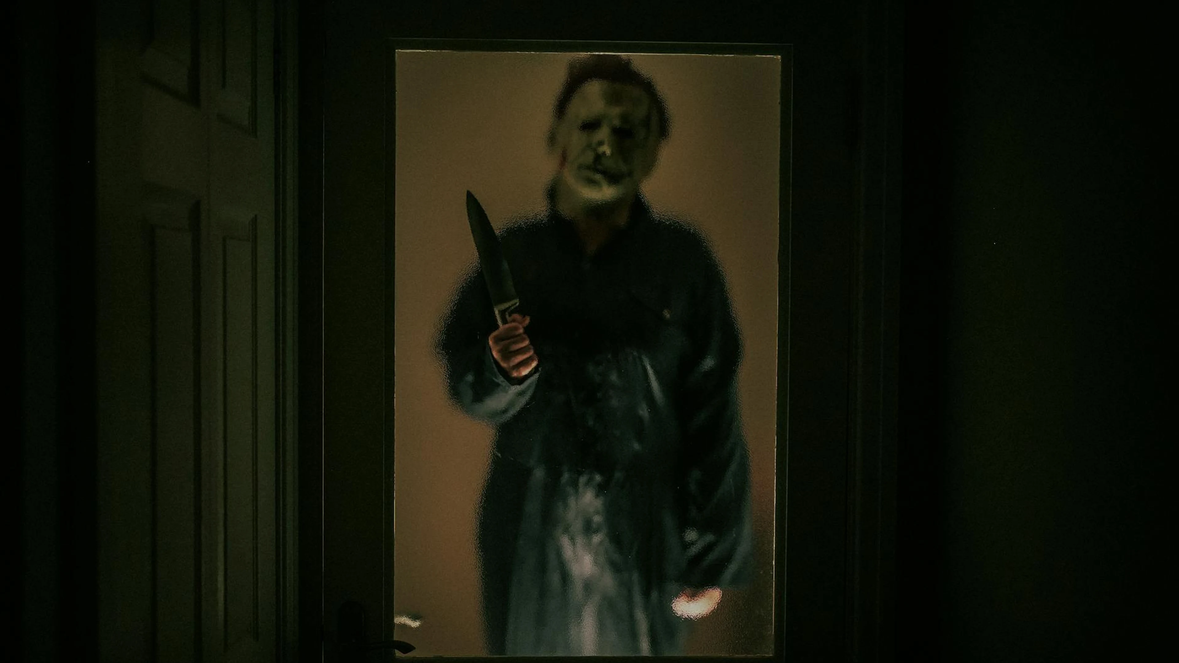 A spooky masked figure stands outside a dimly lit door, creating a chilling Hall - free 4K Ultra HD dark wallpaper for desktop