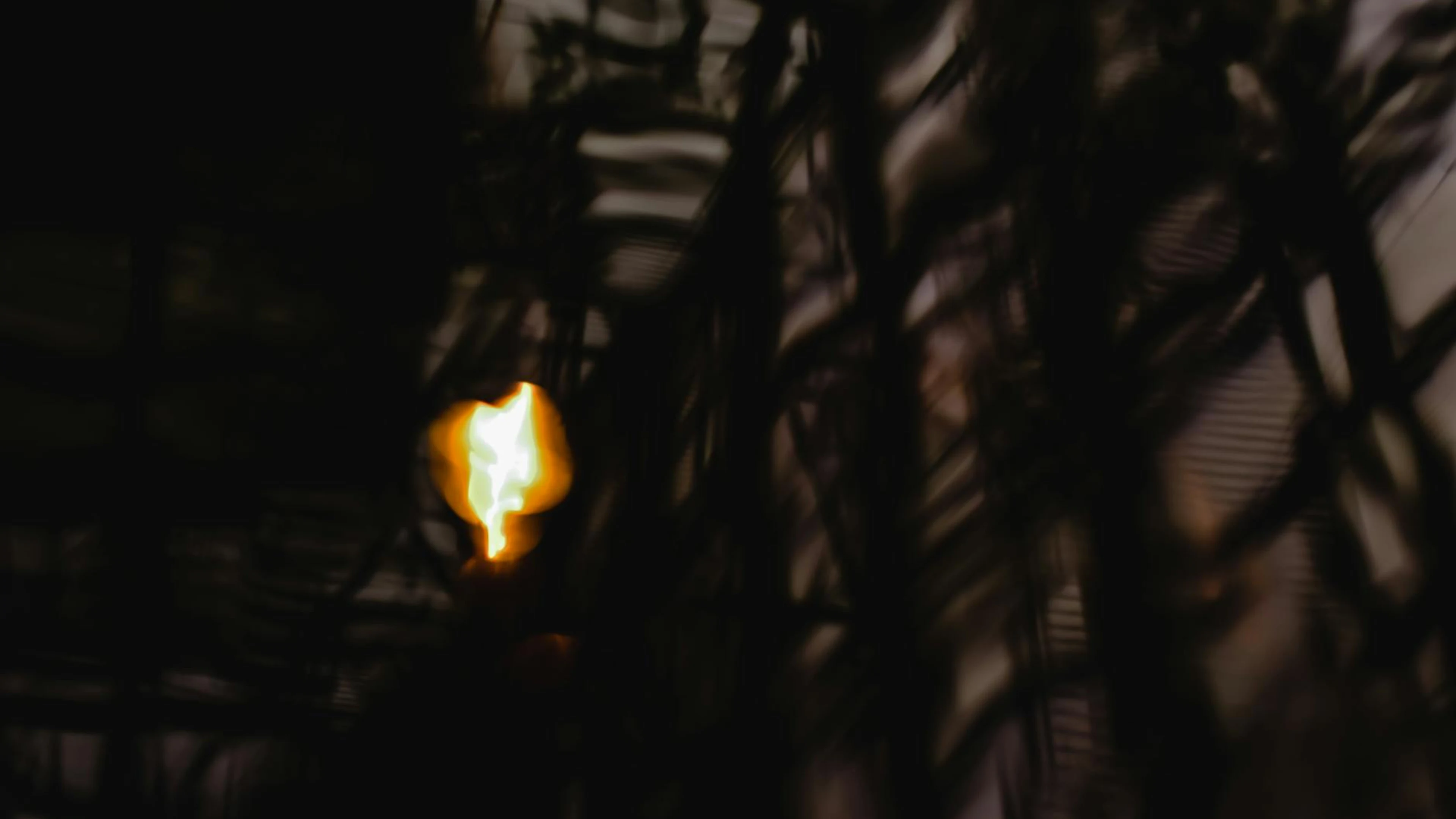 Blurred, artistic depiction of light amidst dark abstract patterns, creating a m - free 4K Ultra HD dark wallpaper for desktop