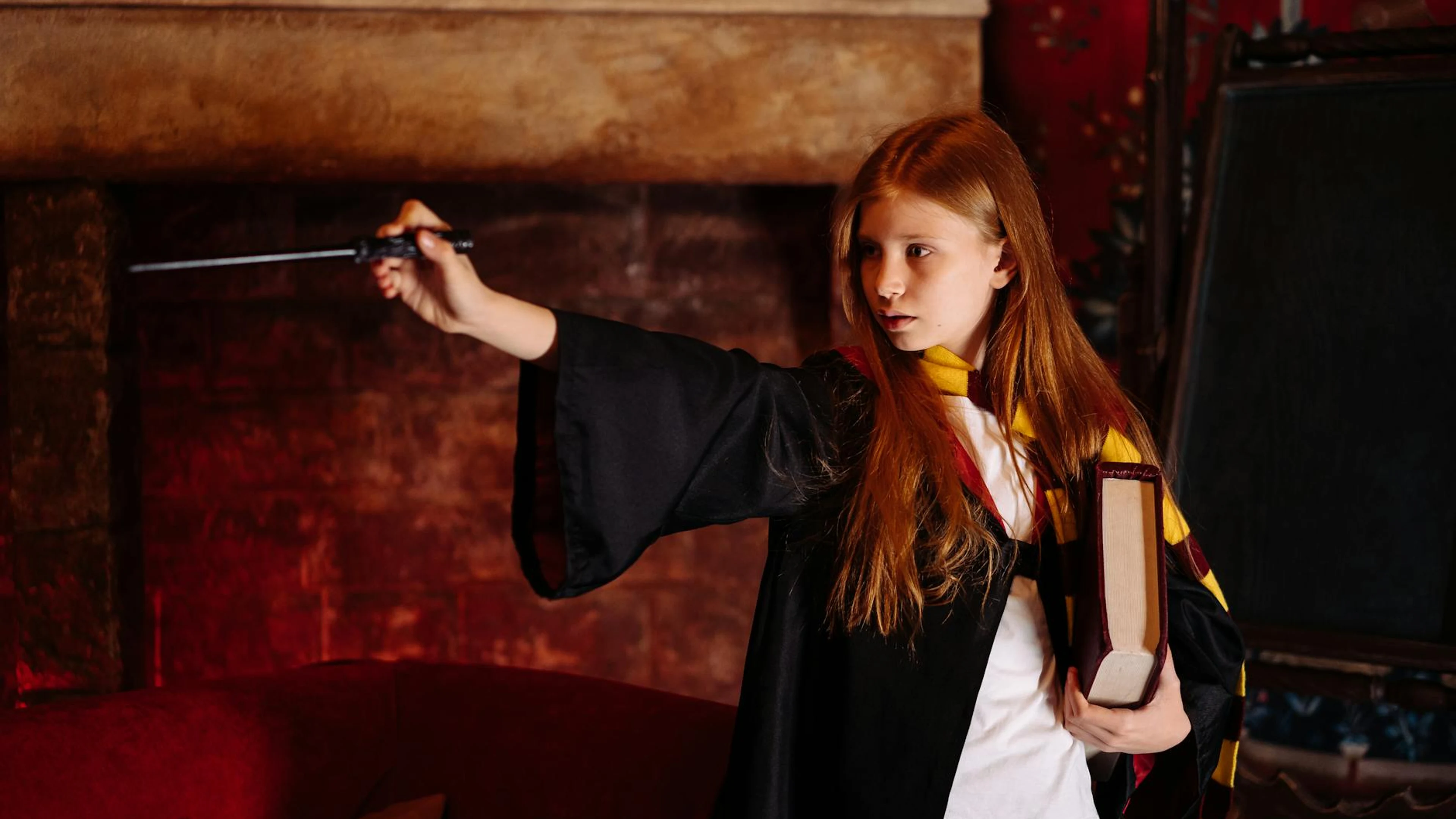 A young girl in wizarding attire practicing magic with a wand near a fireplace. - free 4K Ultra HD fantasy wallpaper for desktop