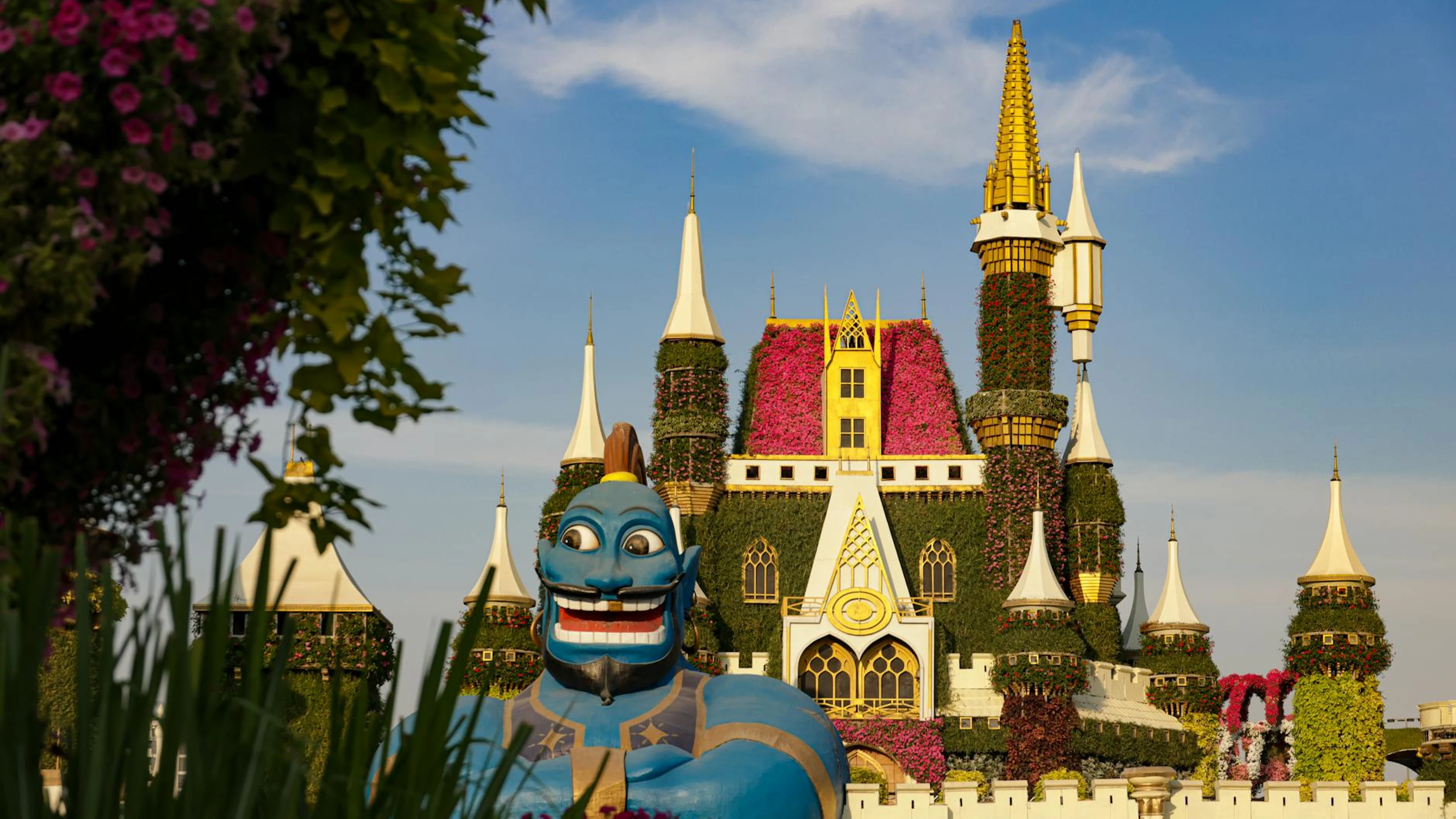 Enchanting garden castle with vibrant flowers and a whimsical blue genie statue - free 4K Ultra HD fantasy wallpaper for desktop