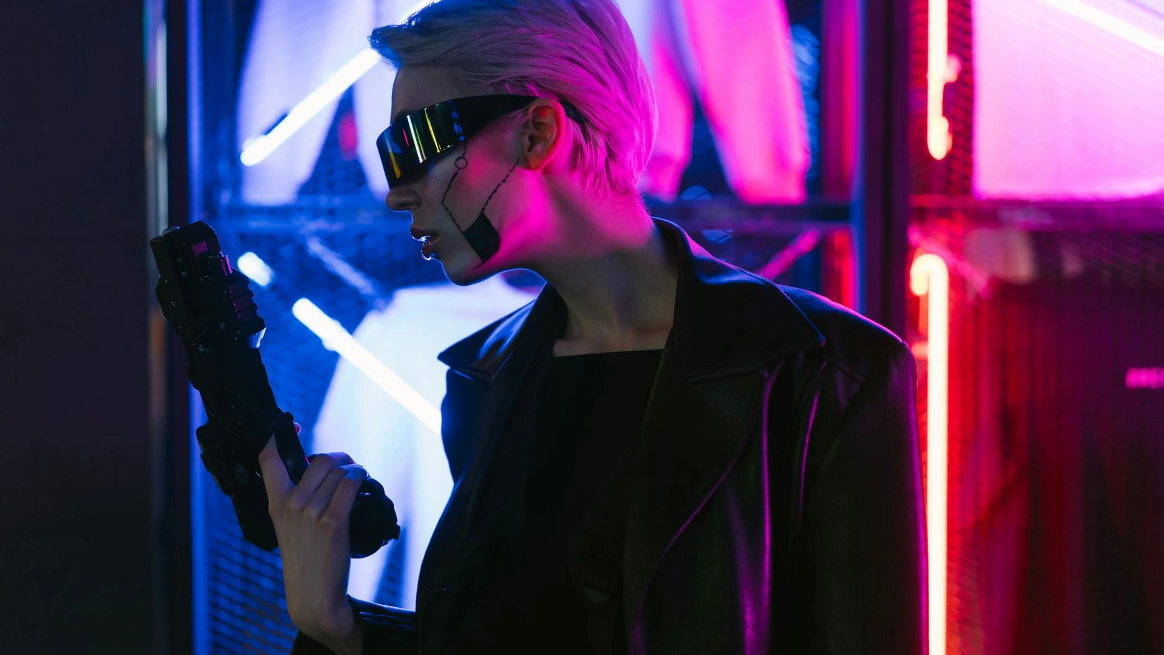 A woman in cyberpunk attire holding a gun, set against vibrant neon lights. - free 4K Ultra HD gaming wallpaper for desktop