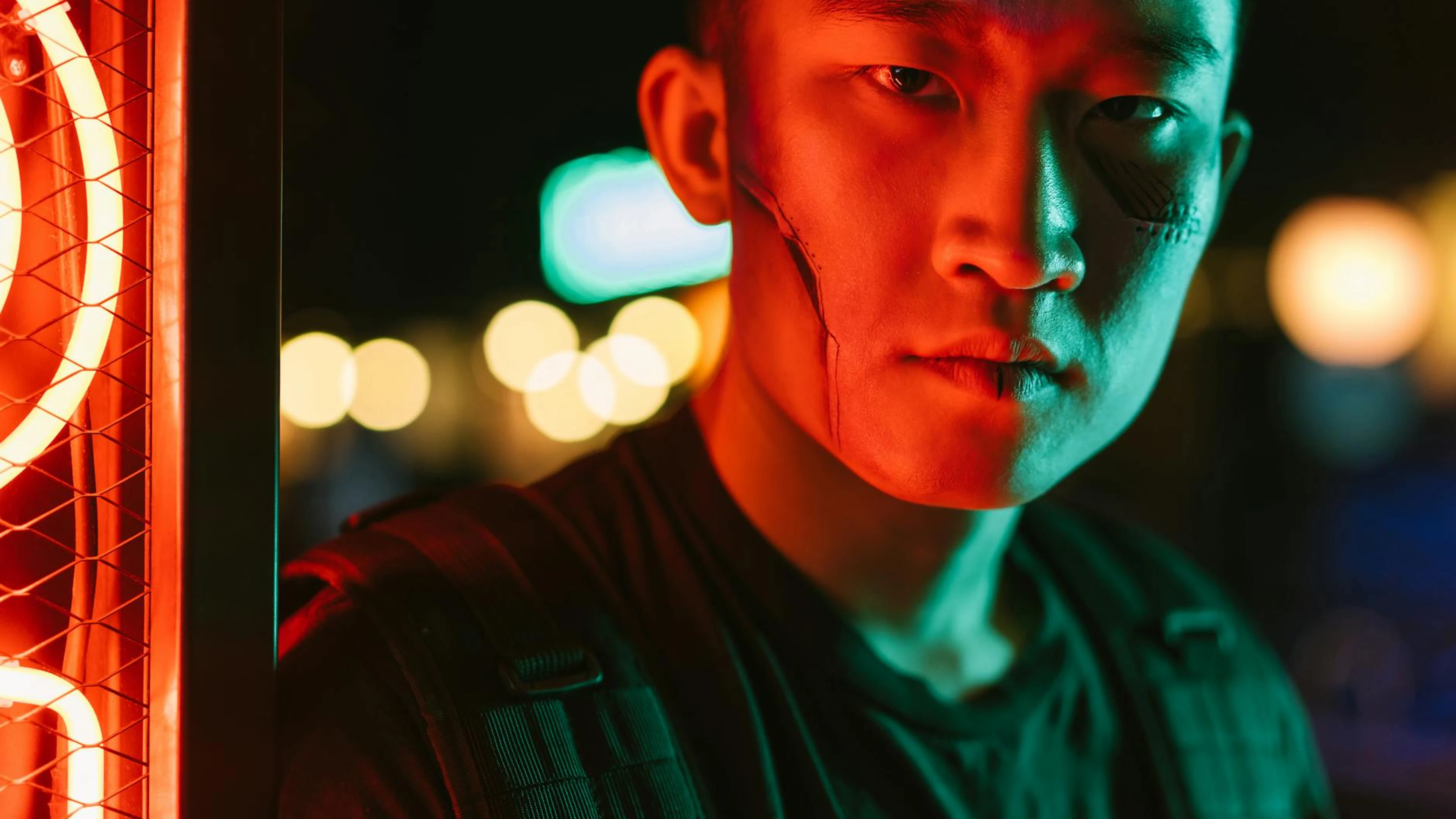 Close-up of a serious man in a cyberpunk setting with neon lighting and futurist - free 4K Ultra HD gaming wallpaper for desktop