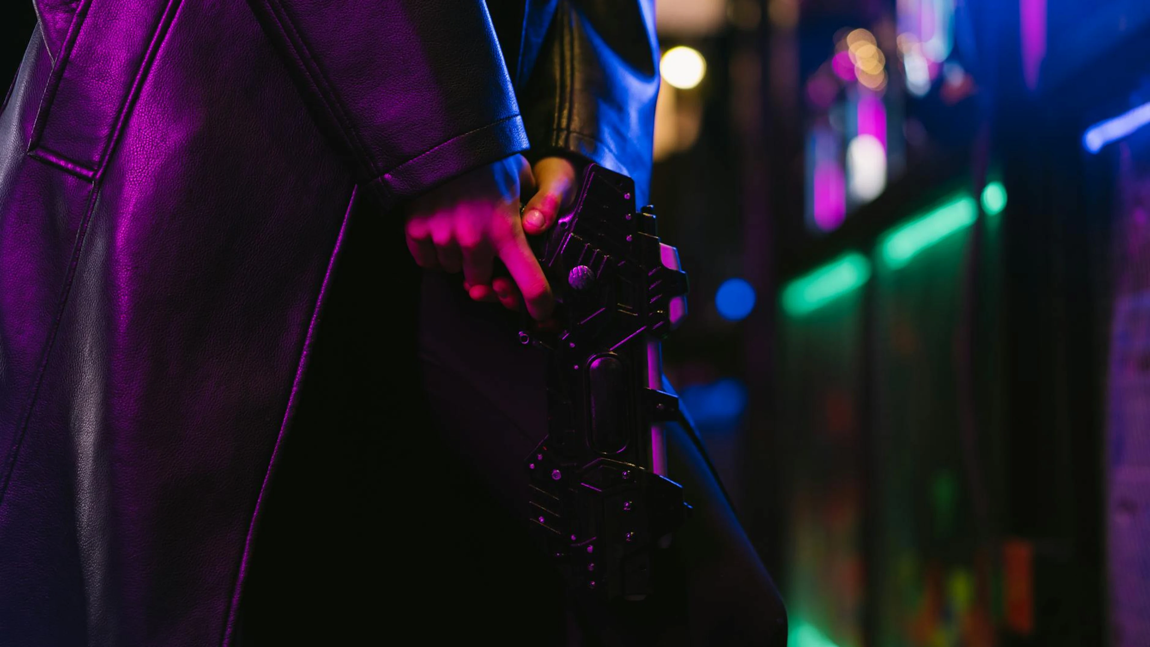 Dark, cyberpunk image of a futuristic style person holding a gun in neon light. - free 4K Ultra HD gaming wallpaper for desktop
