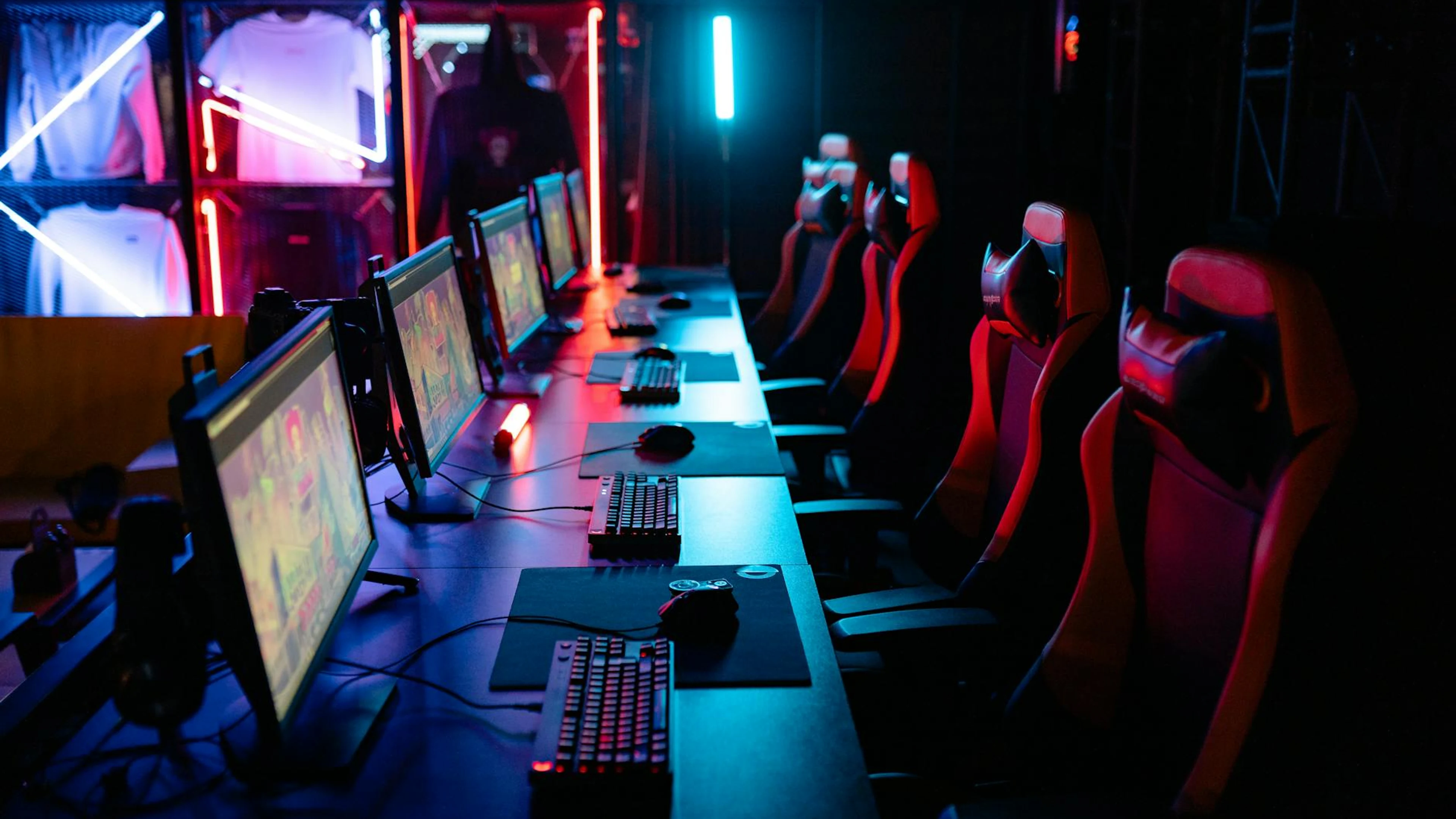 High-tech gaming setup with PCs, RGB lighting, and gaming chairs in a gaming hou - free 4K Ultra HD gaming wallpaper for desktop