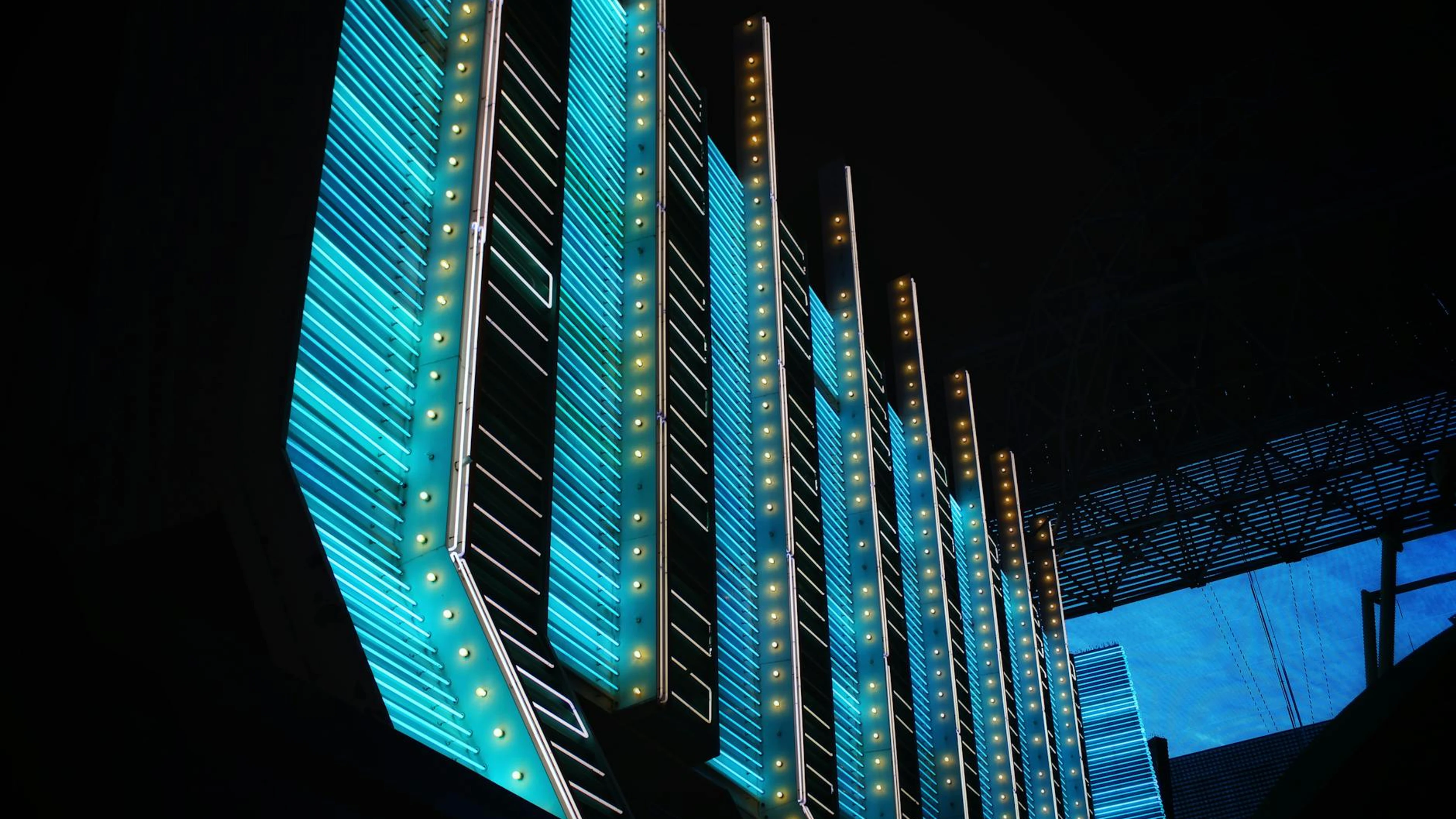 Vibrant neon lights illuminate modern architecture in the heart of Las Vegas at - free 4K Ultra HD gaming wallpaper for desktop