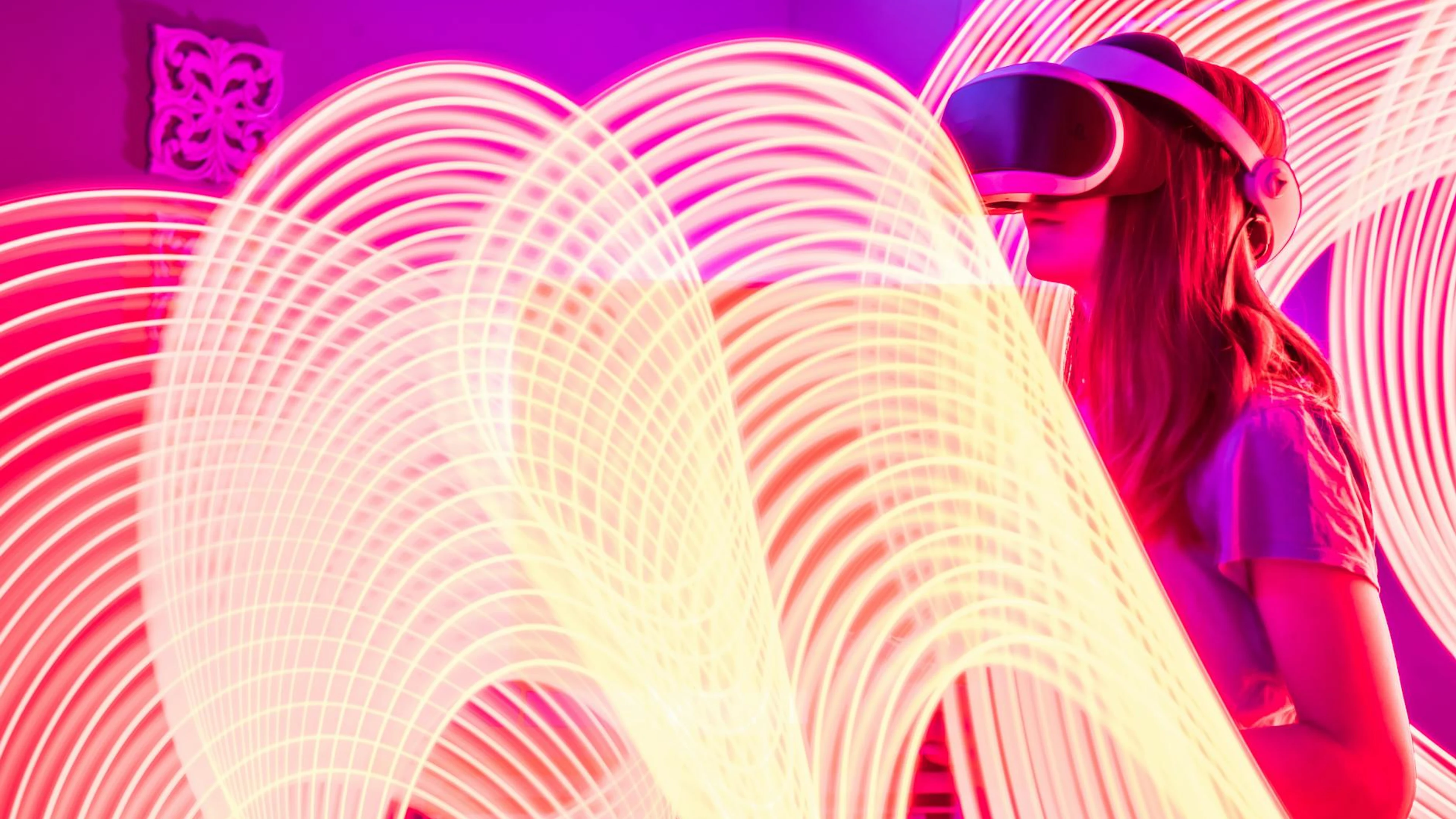 Woman wearing VR glasses surrounded by vibrant neon light trails for a futuristi - free 4K Ultra HD gaming wallpaper for desktop