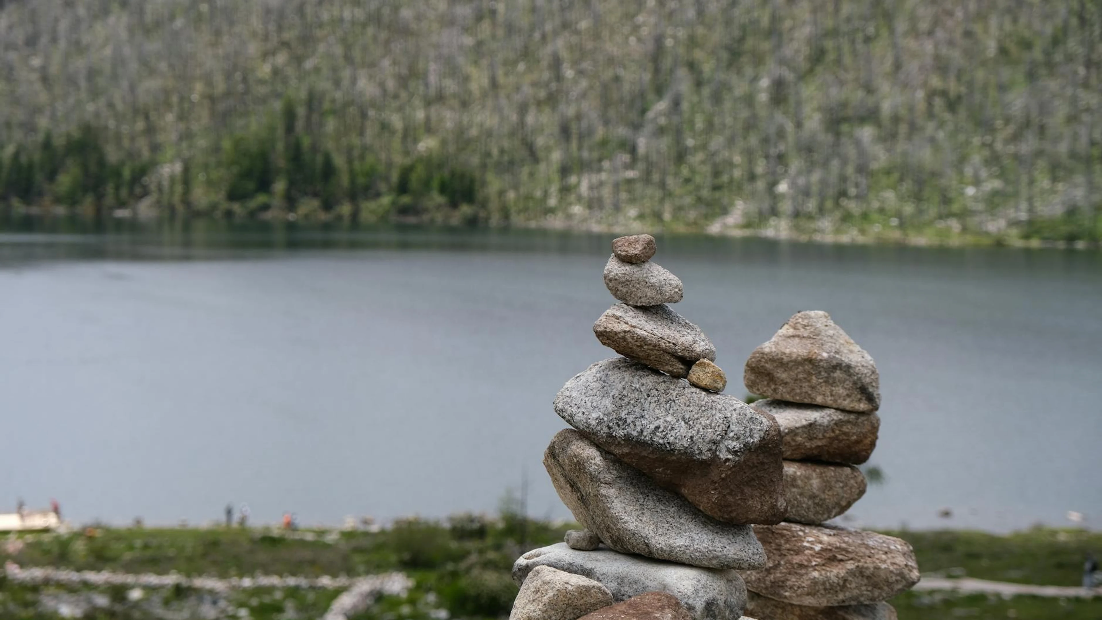 A peaceful stone stack by a calm lake in China, perfect for zen and tranquility - free 4K Ultra HD lake wallpaper for desktop