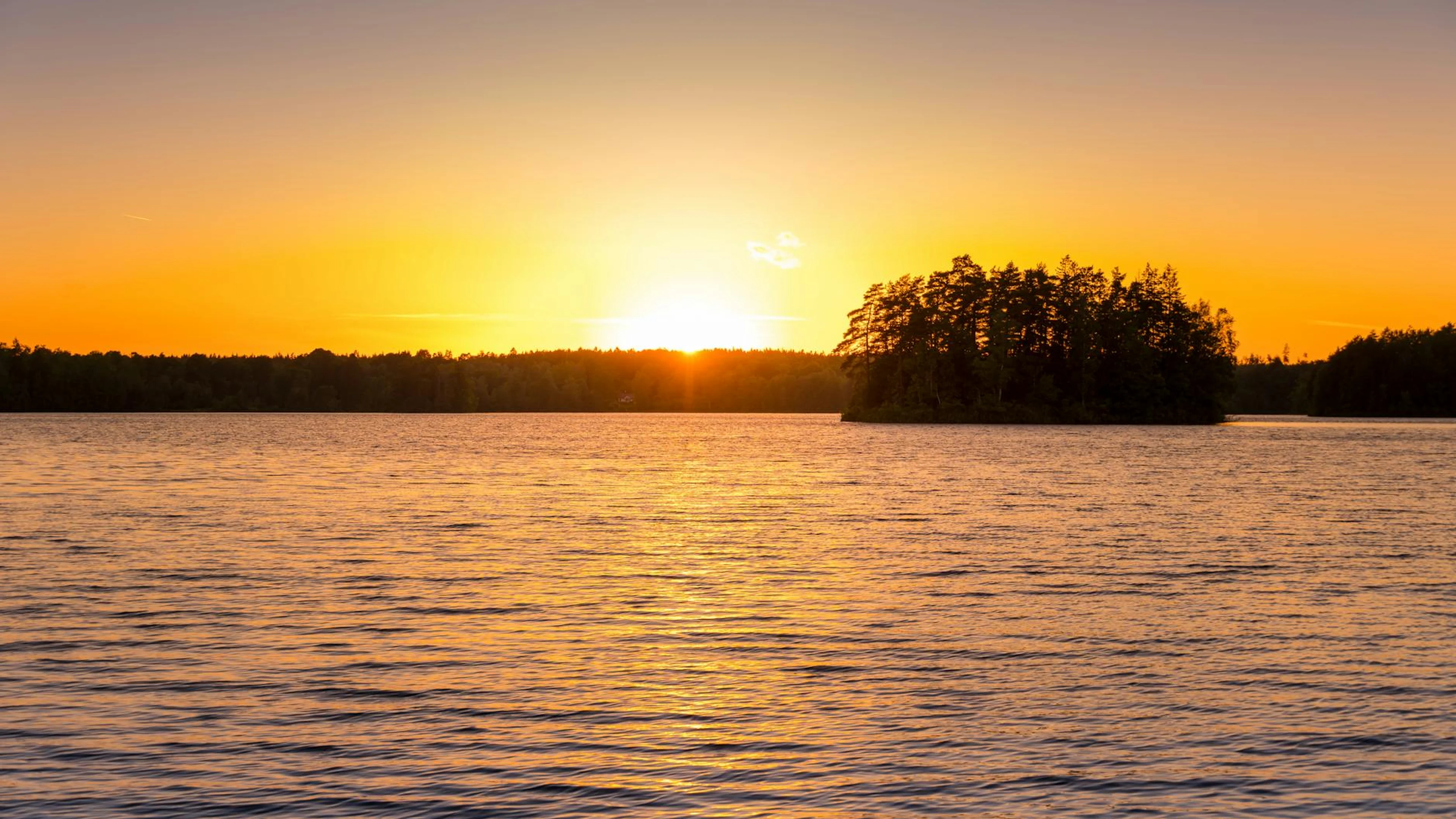 Beautiful island silhouette at sunset over a calm lake. Perfect for nature lover - free 4K Ultra HD lake wallpaper for desktop