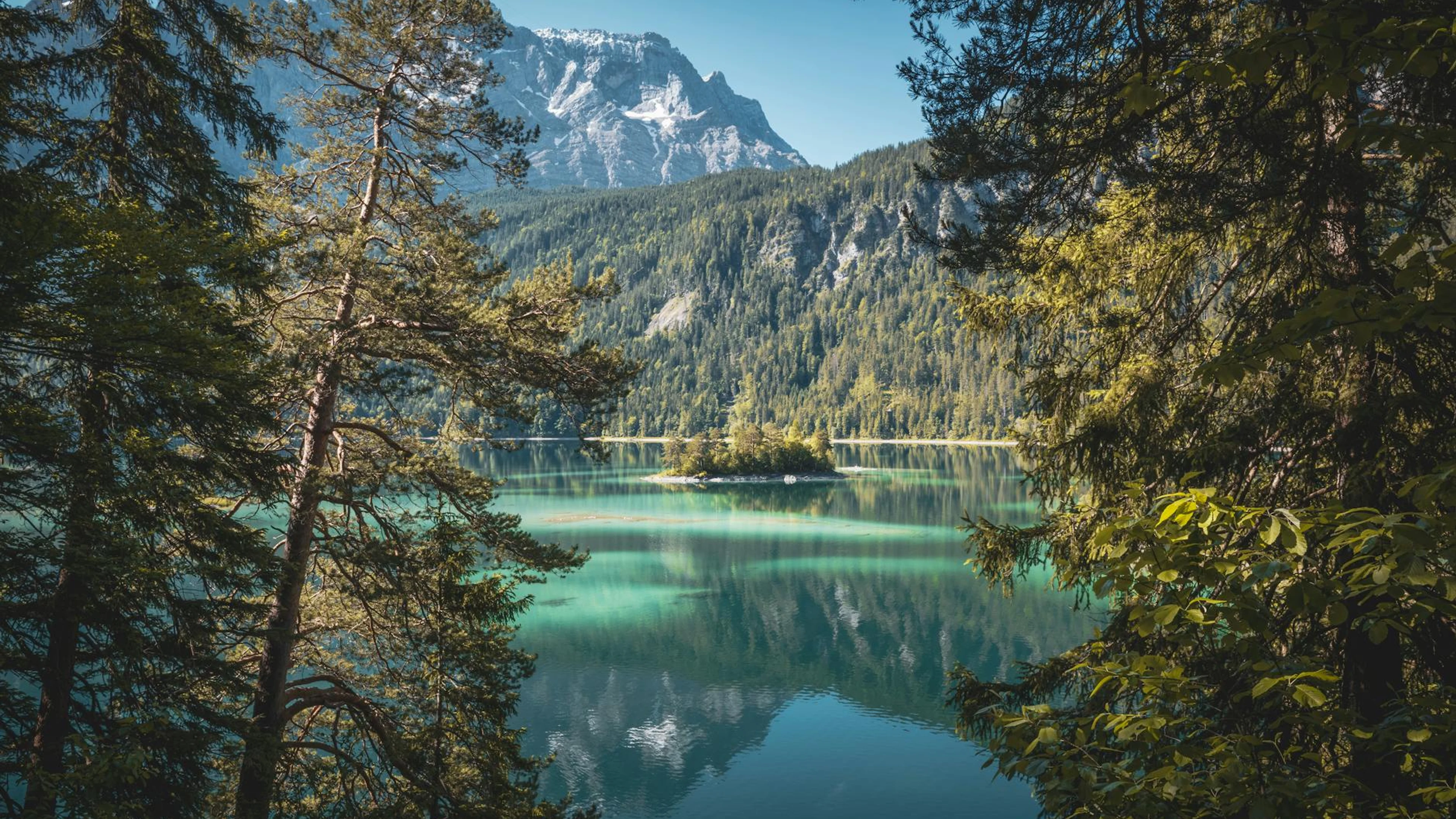 Breathtaking view of Eibsee Lake reflecting the Bavarian Alps surrounded by lush - free 4K Ultra HD lake wallpaper for desktop