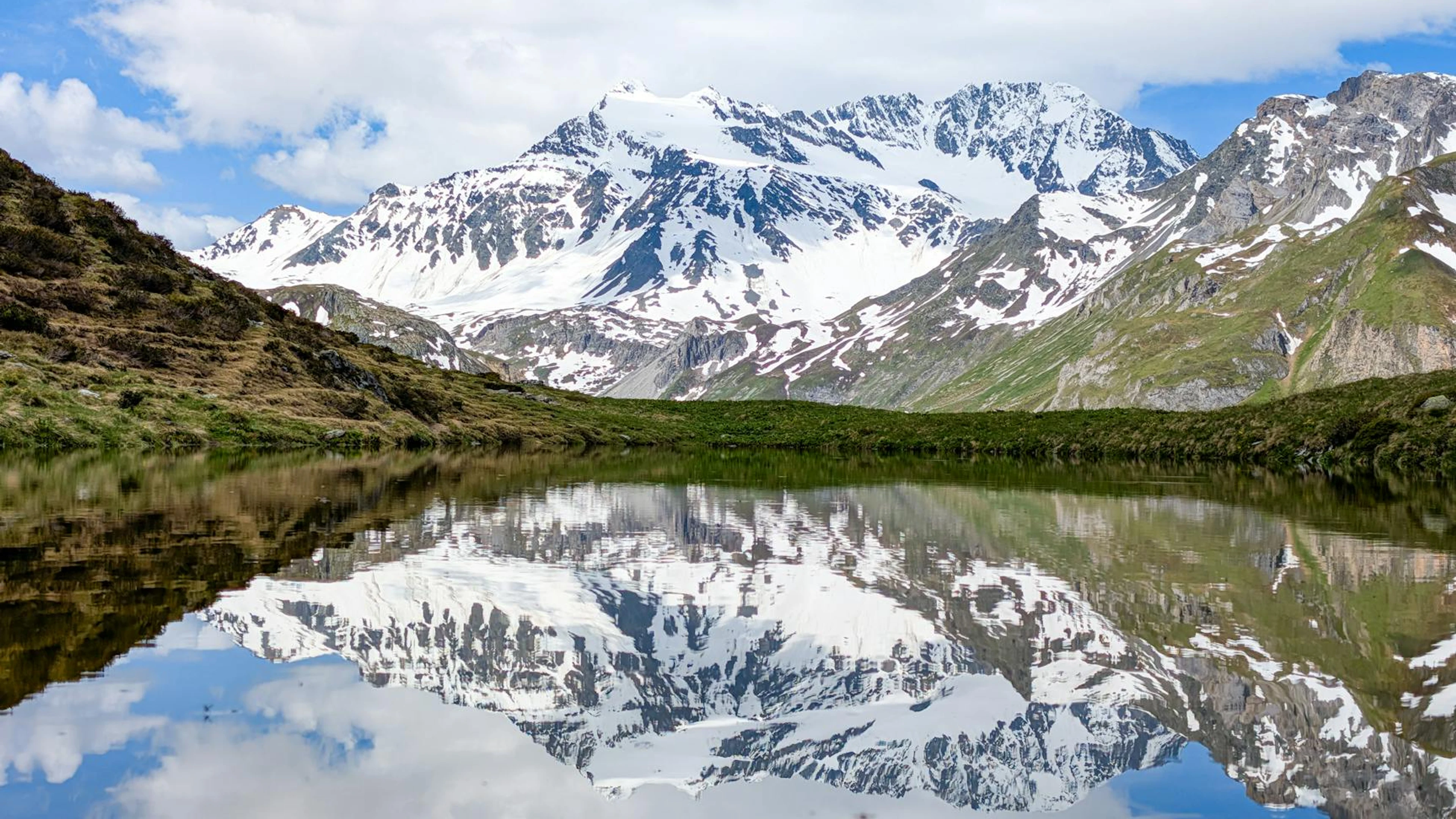 Explore the serene reflection of the snow-capped Vanoise Mountains in a tranquil - free 4K Ultra HD lake wallpaper for desktop