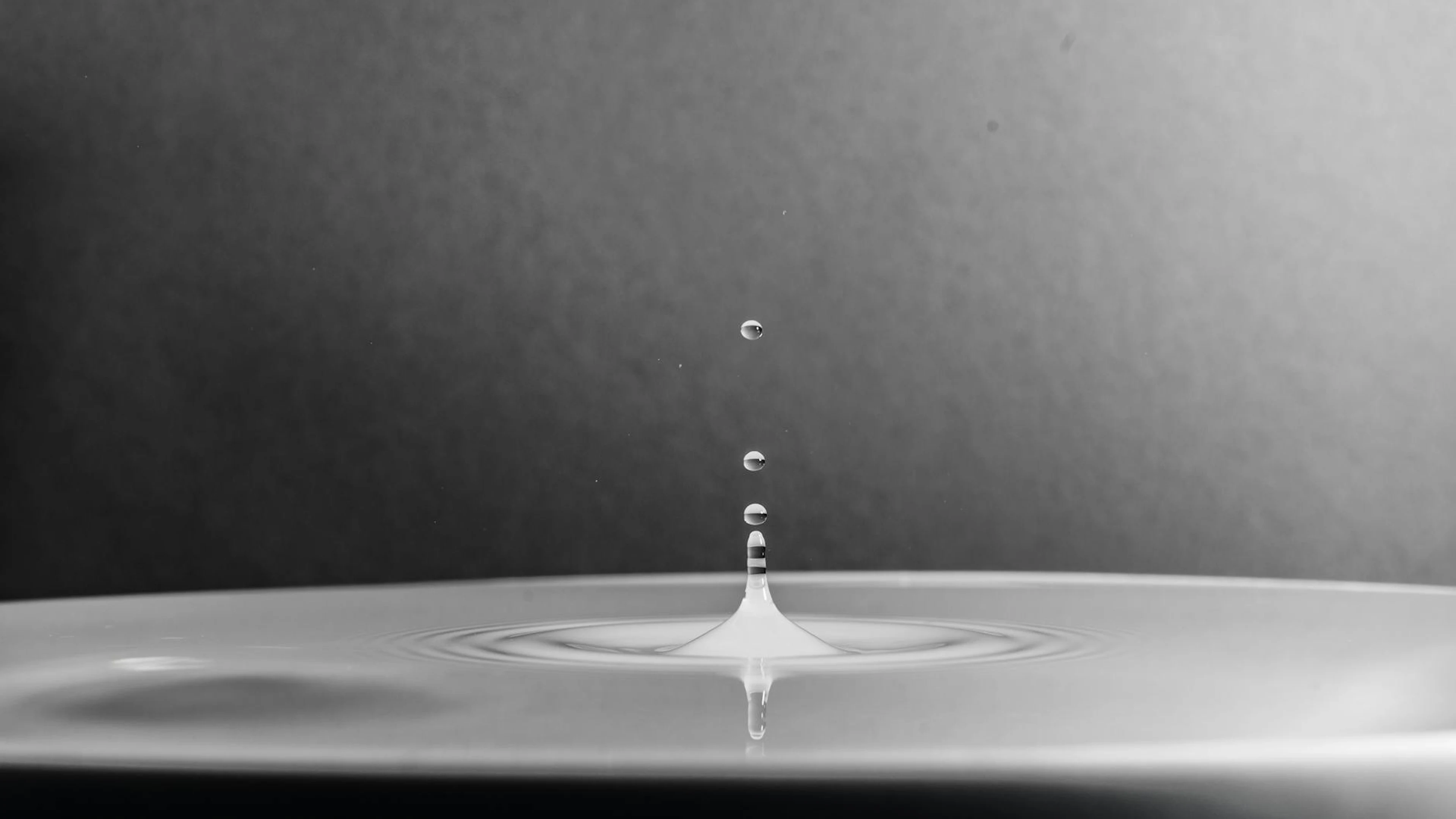 A high-definition macro shot capturing a water drop splash in black and white. - free 4K Ultra HD macro wallpaper for desktop