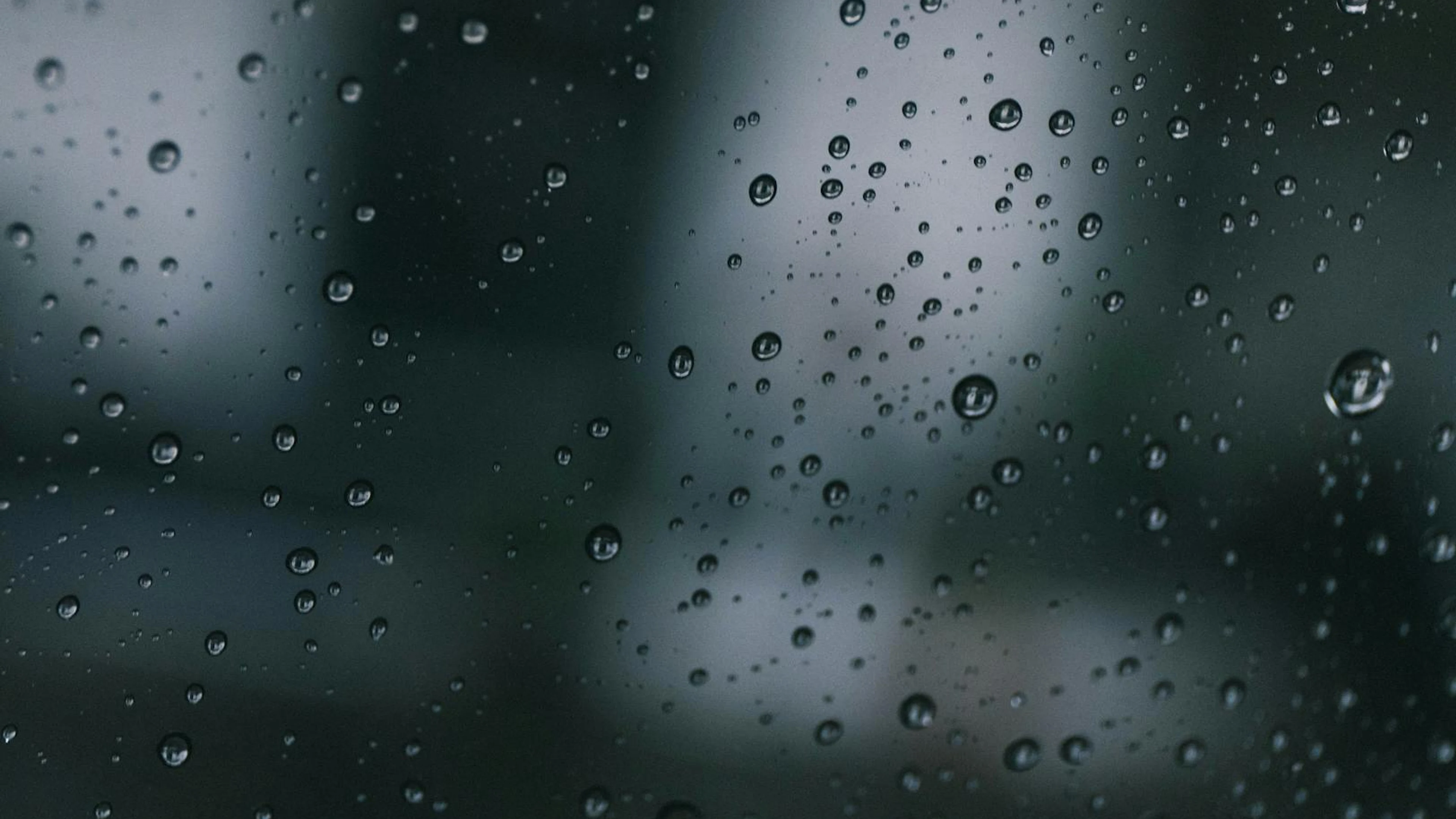 Detailed macro photo capturing water droplets on glass with a moody backdrop. - free 4K Ultra HD macro wallpaper for desktop