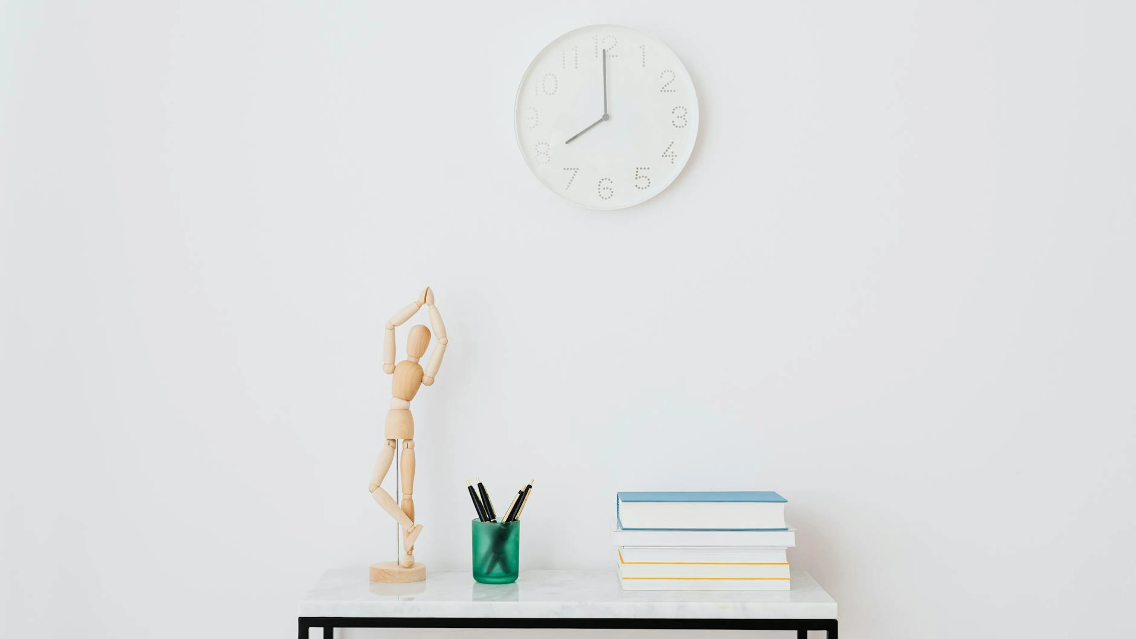 A minimalist workspace setup featuring books, a clock, and decorative elements o - free 4K Ultra HD minimal wallpaper for desktop