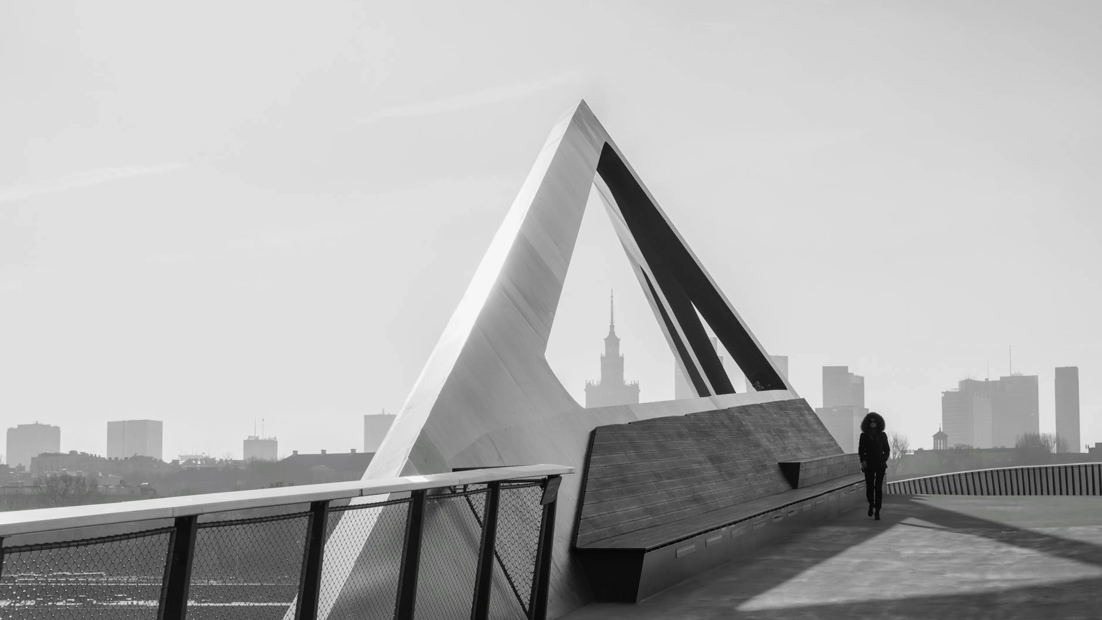 Black and white image of a modern triangular structure with Warsaw skyline in th - free 4K Ultra HD minimal wallpaper for desktop