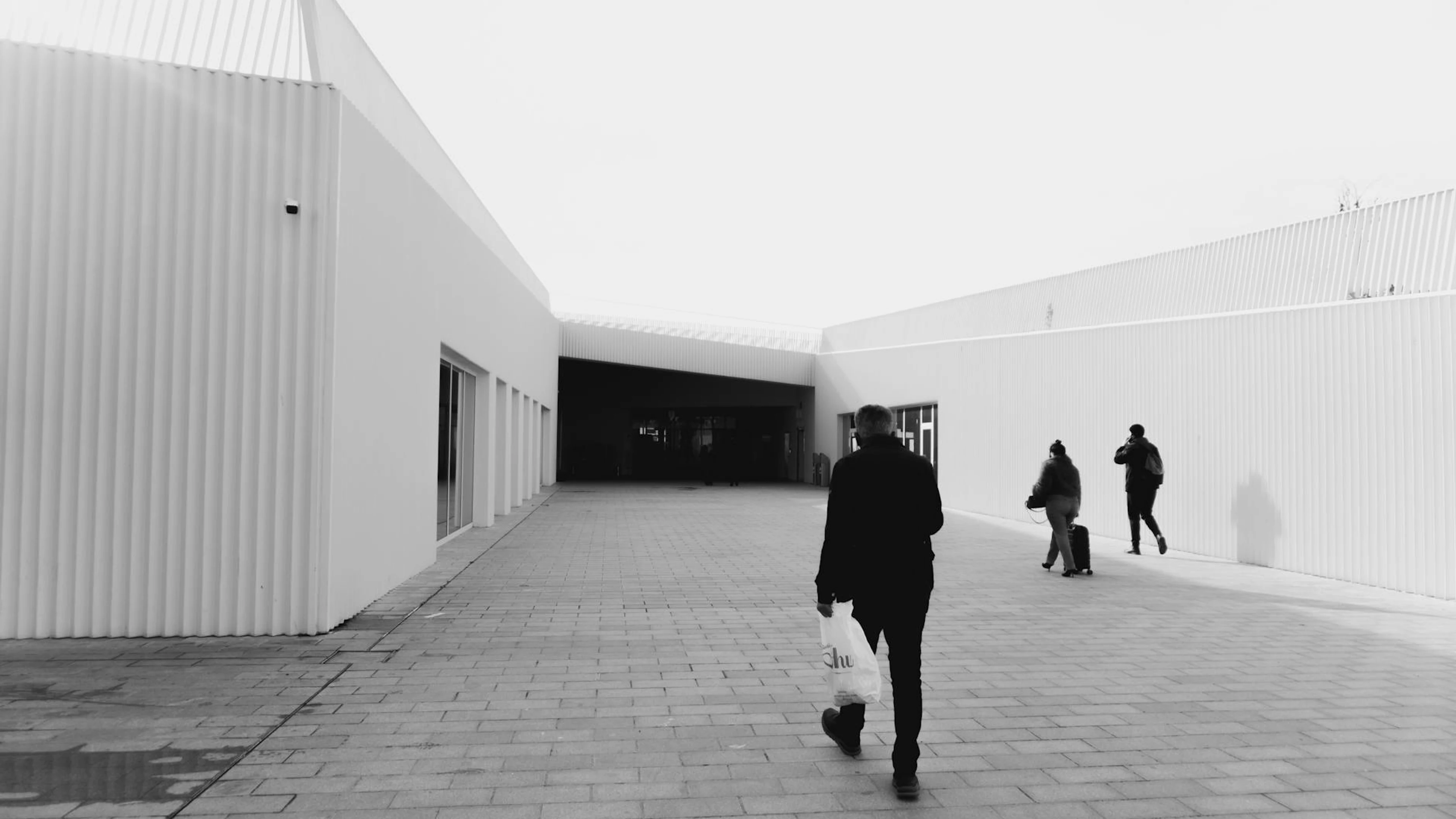 Monochrome minimalist urban scene with people walking past modern architecture i - free 4K Ultra HD minimal wallpaper for desktop