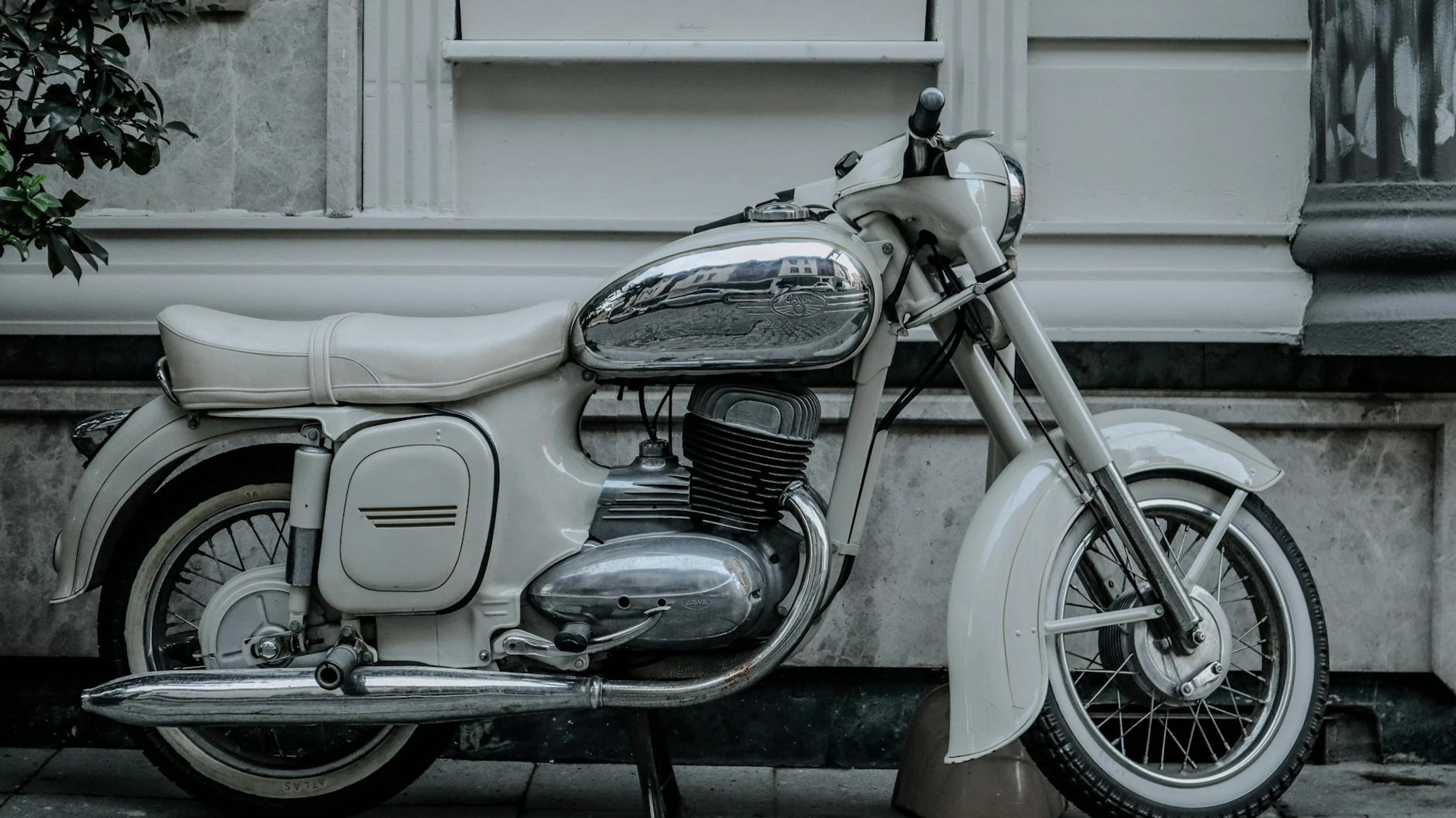 A classic Jawa 353 motorcycle parked by a city building showcases vintage chrome - free 4K Ultra HD motorcycle wallpaper for desktop