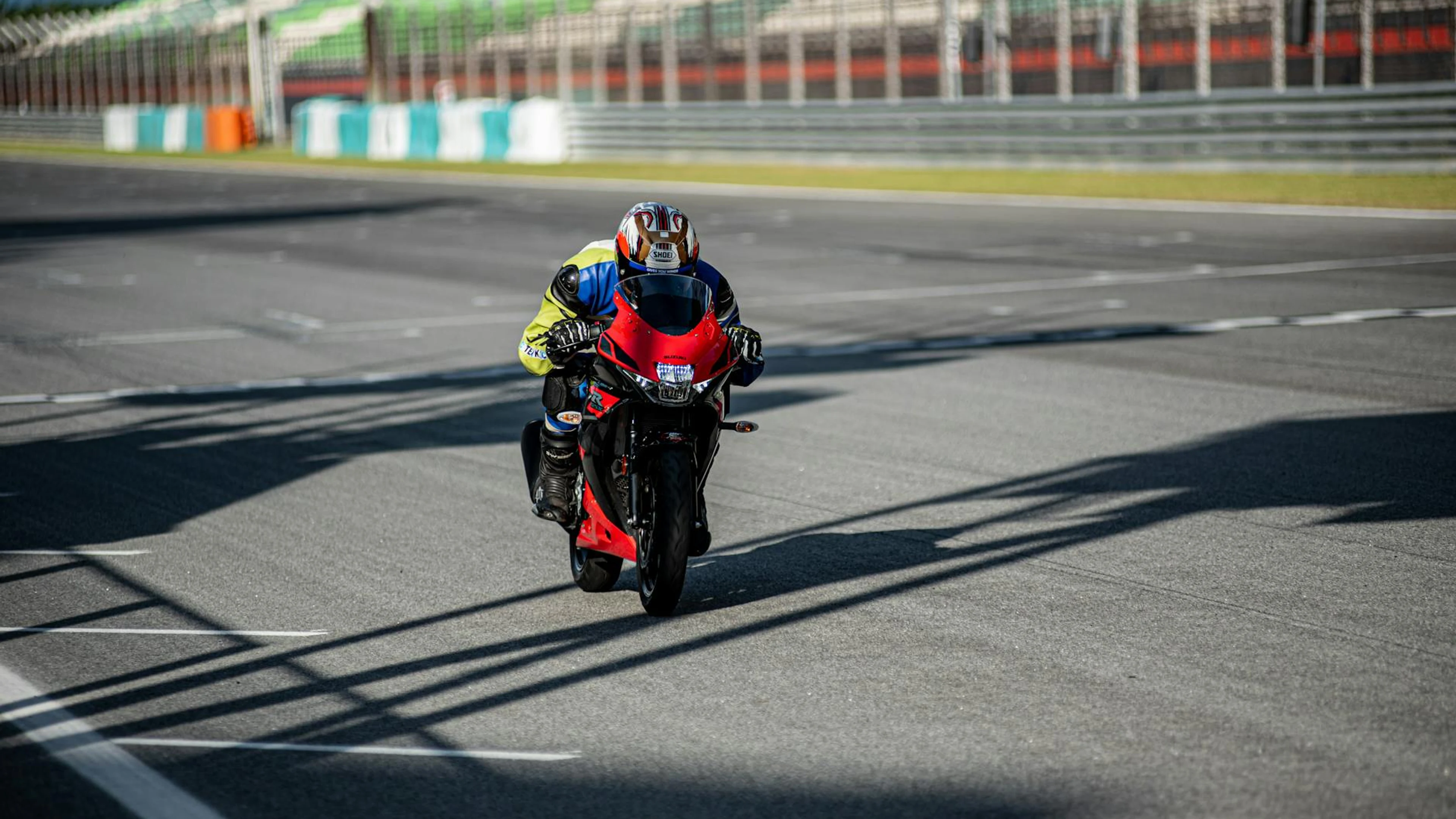 A male motorcyclist in full gear is racing on a track during the day, showcasing - free 4K Ultra HD motorcycle wallpaper for desktop