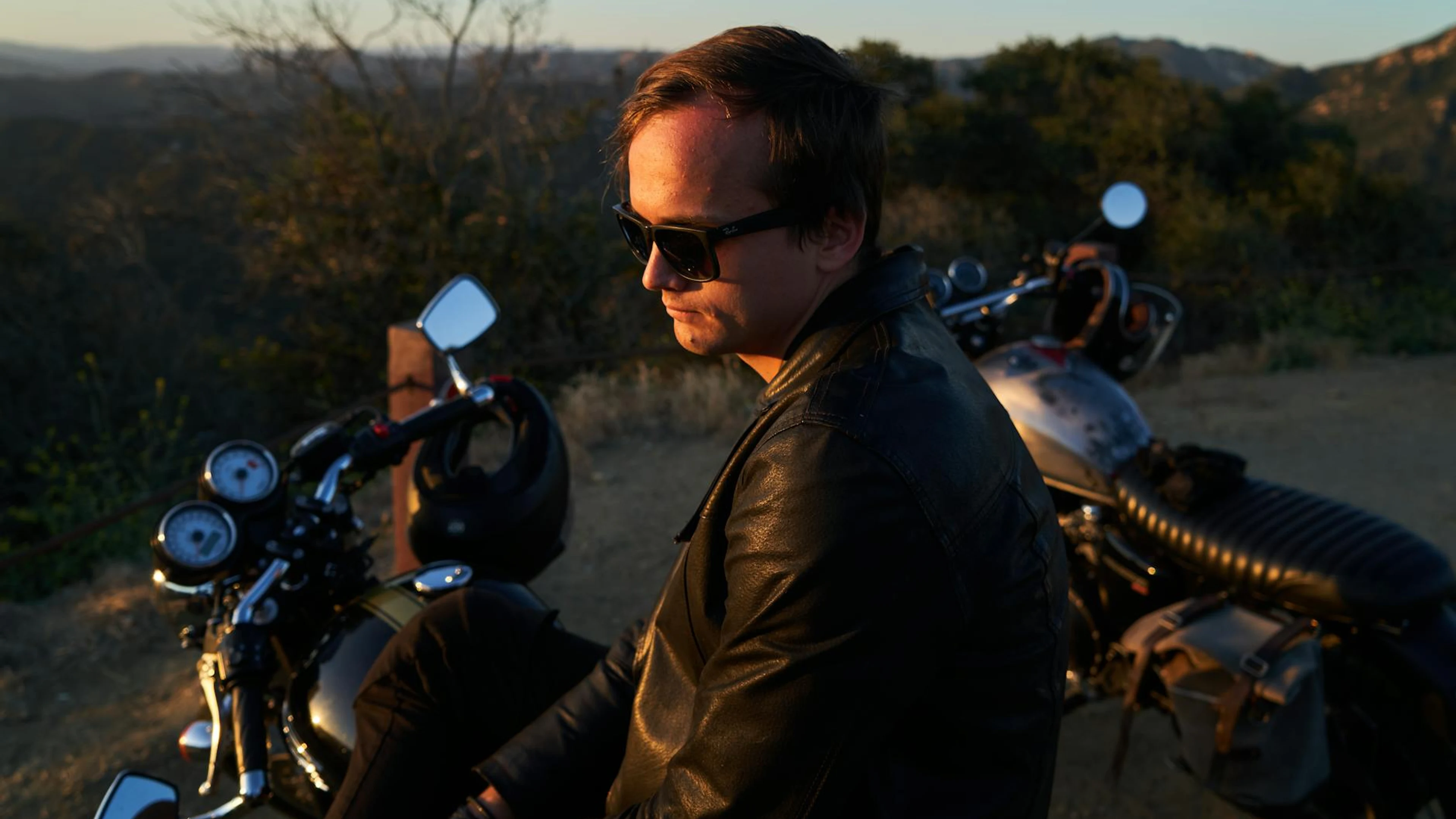 A man in a black leather jacket sitting on a motorcycle at sunset, scenic outdoo - free 4K Ultra HD motorcycle wallpaper for desktop