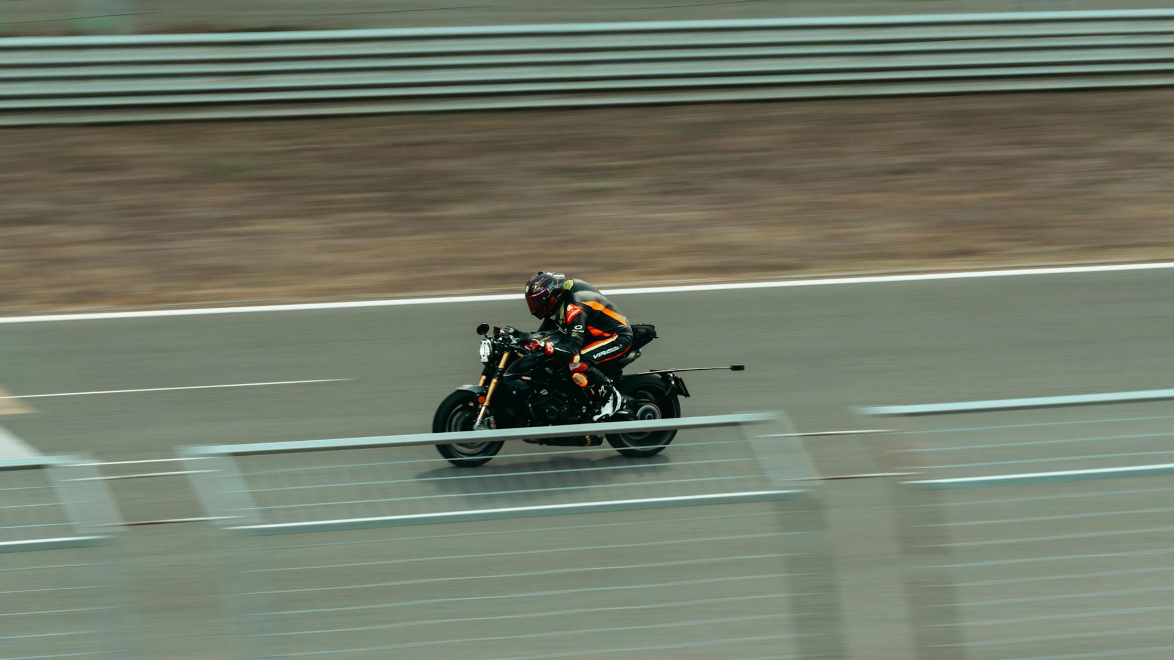 Blurred image of a motorcyclist racing at high speed on an outdoor track. - free 4K Ultra HD motorcycle wallpaper for desktop