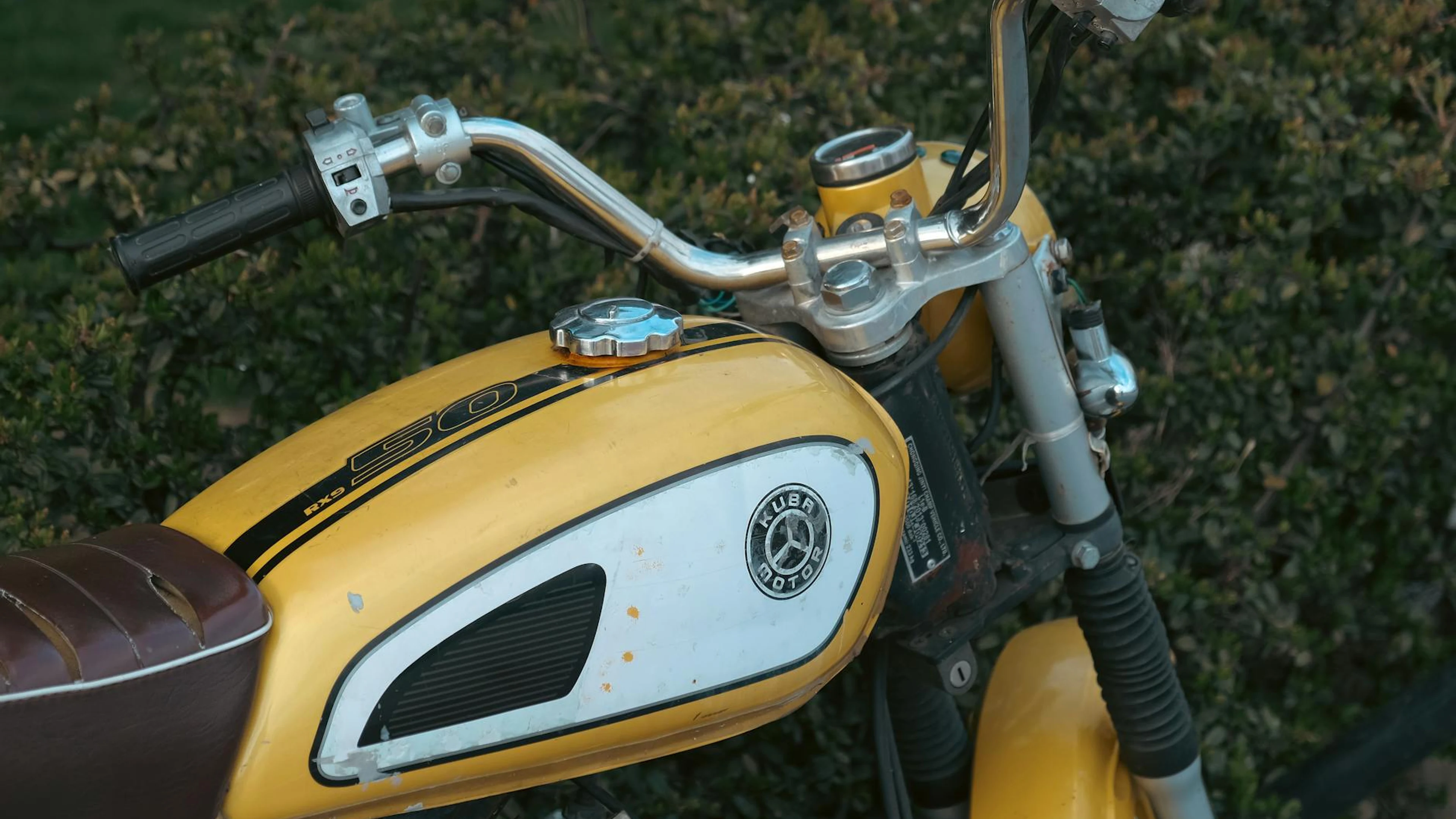 Close-up of a vintage yellow motorcycle tank, embodying retro vibes. - free 4K Ultra HD motorcycle wallpaper for desktop