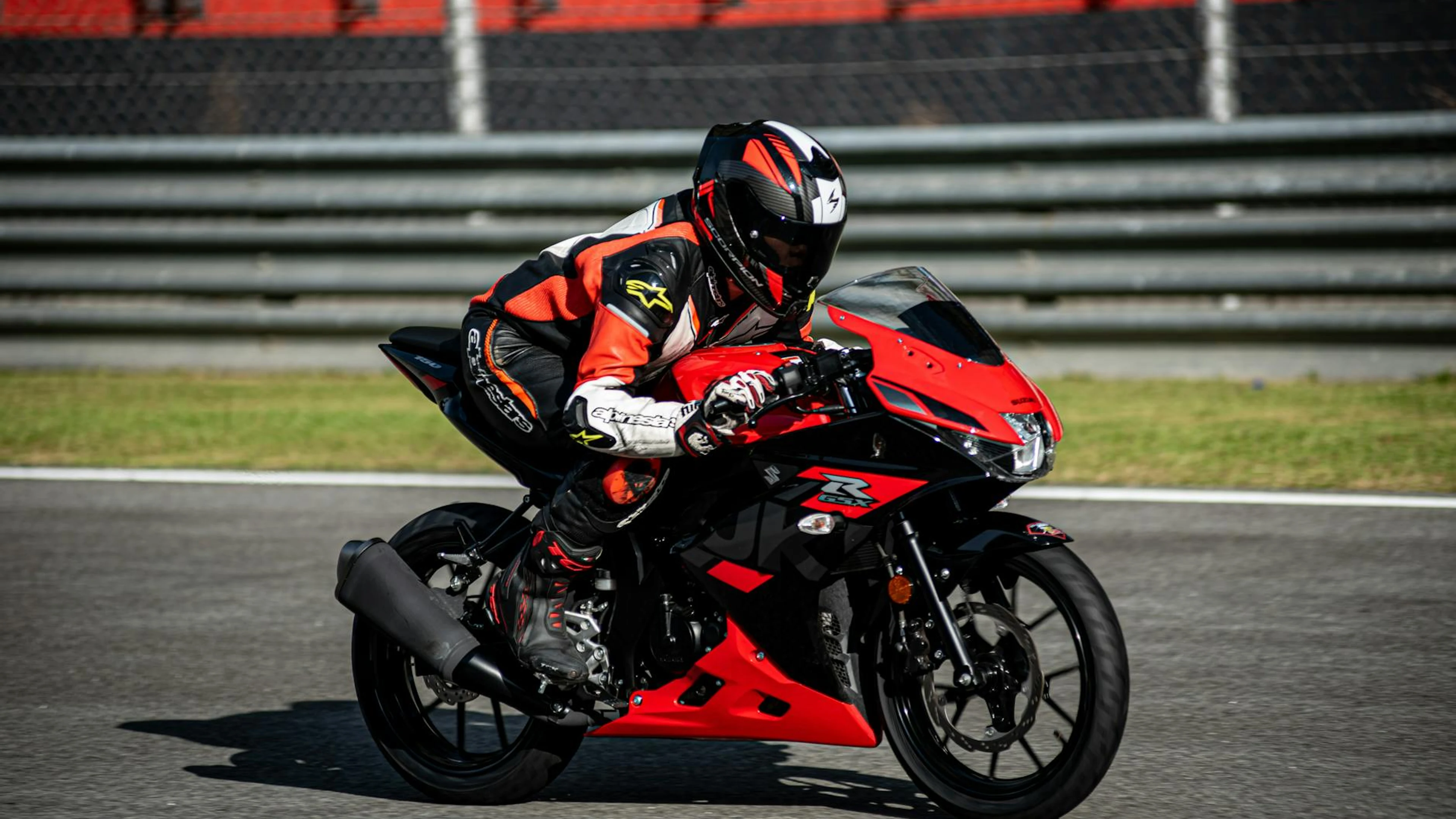 Motorcycle rider in racing suit speeding on asphalt track in daylight. - free 4K Ultra HD motorcycle wallpaper for desktop