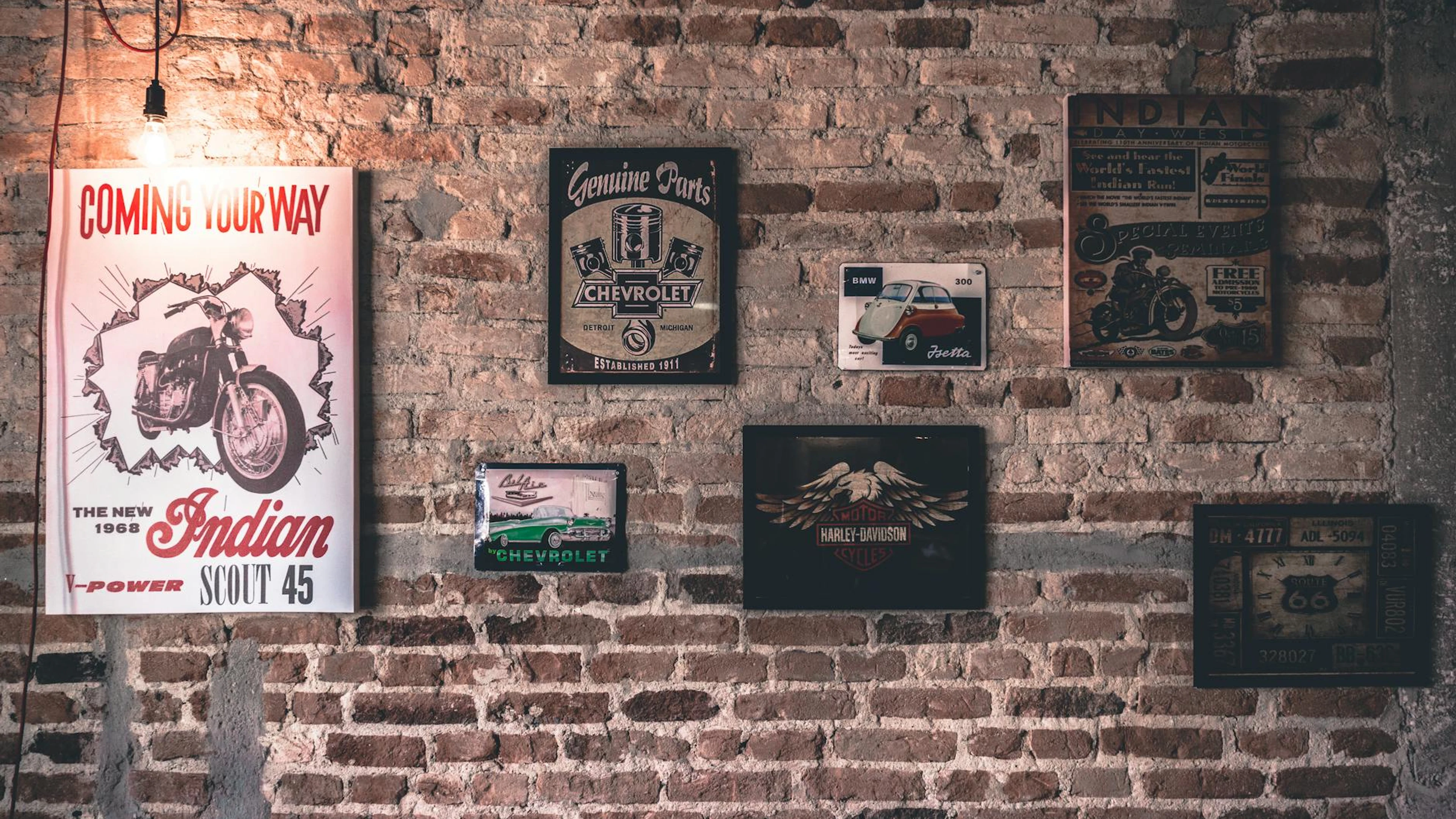 Retro wall art featuring motorcycle and car signs on a rustic brick wall. - free 4K Ultra HD motorcycle wallpaper for desktop