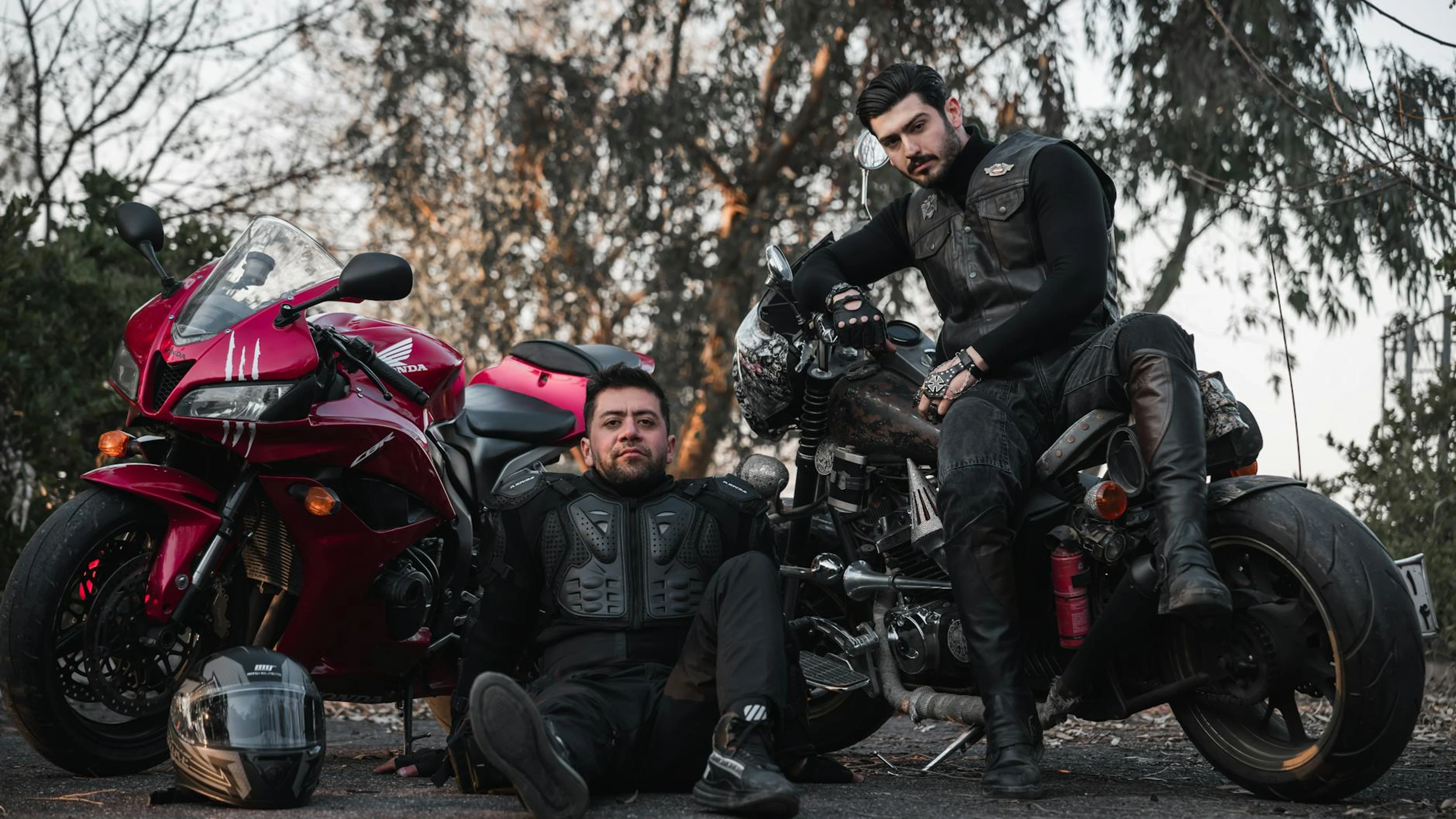 Two bikers in gear pose confidently with motorcycles on an outdoor setting. - free 4K Ultra HD motorcycle wallpaper for desktop