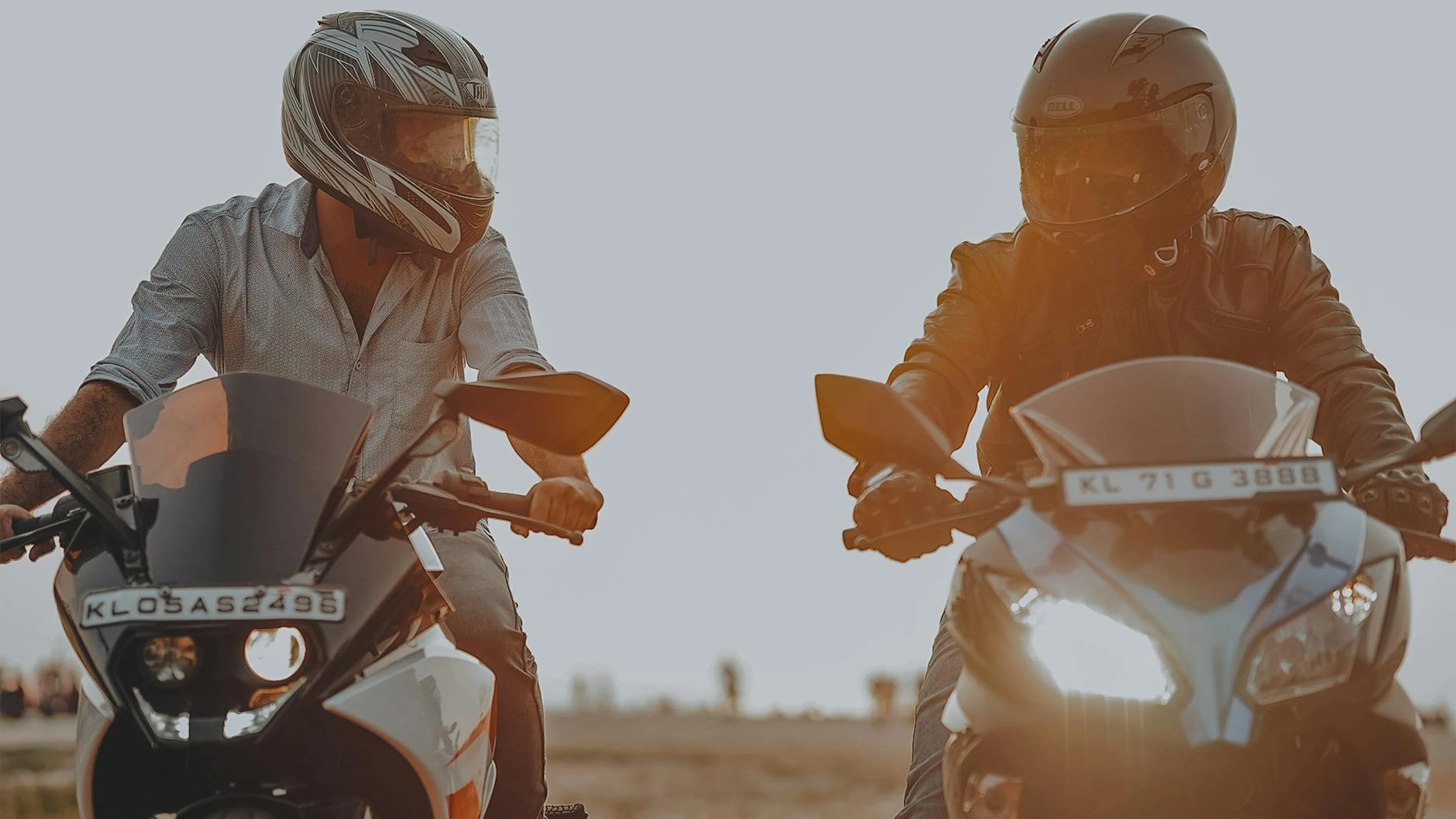 Two men riding motorcycles with helmets during sunset. Action and adventure conc - free 4K Ultra HD motorcycle wallpaper for desktop