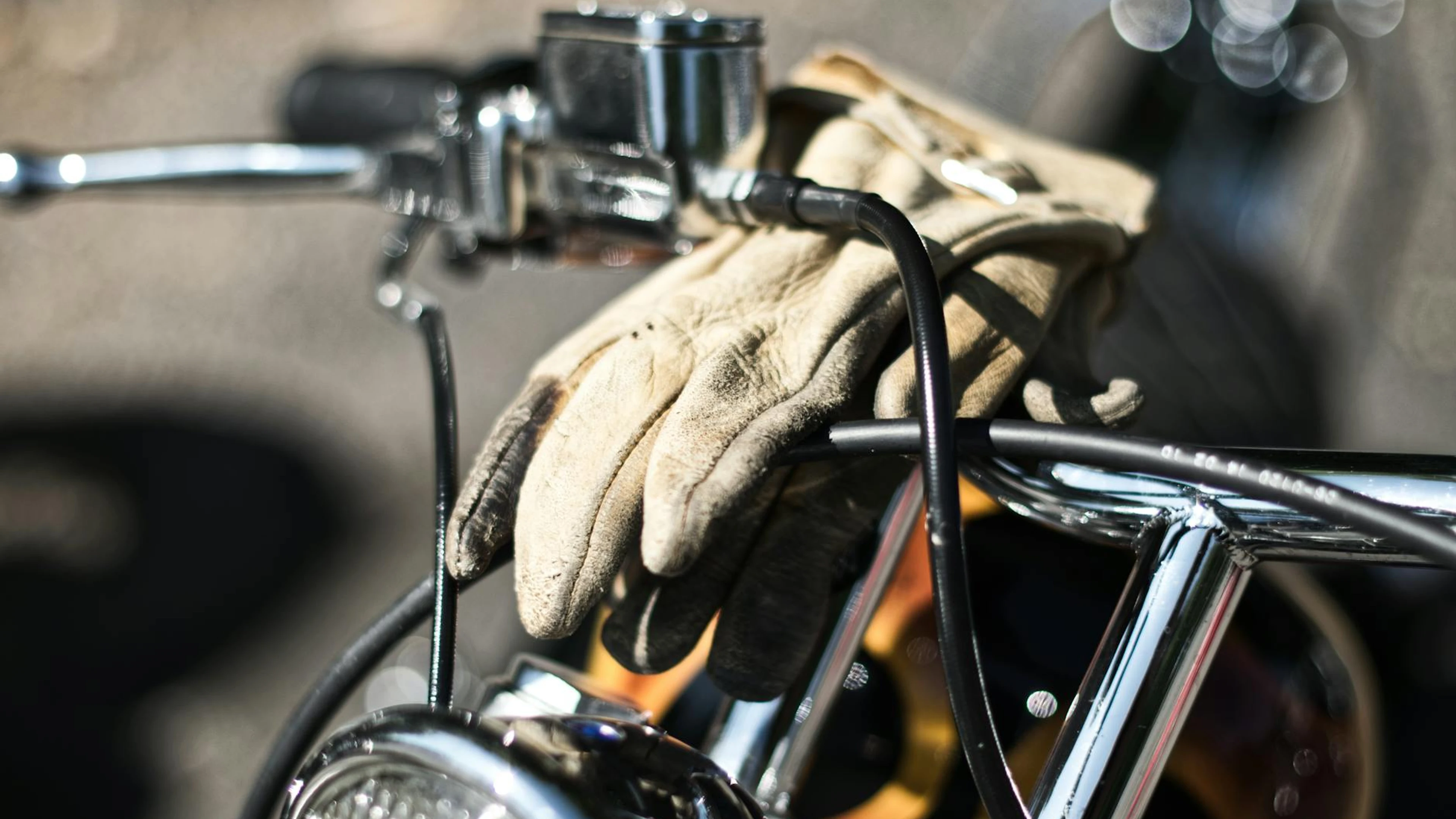 Vintage motorcycle handlebars with leather gloves draped over, highlighting clas - free 4K Ultra HD motorcycle wallpaper for desktop