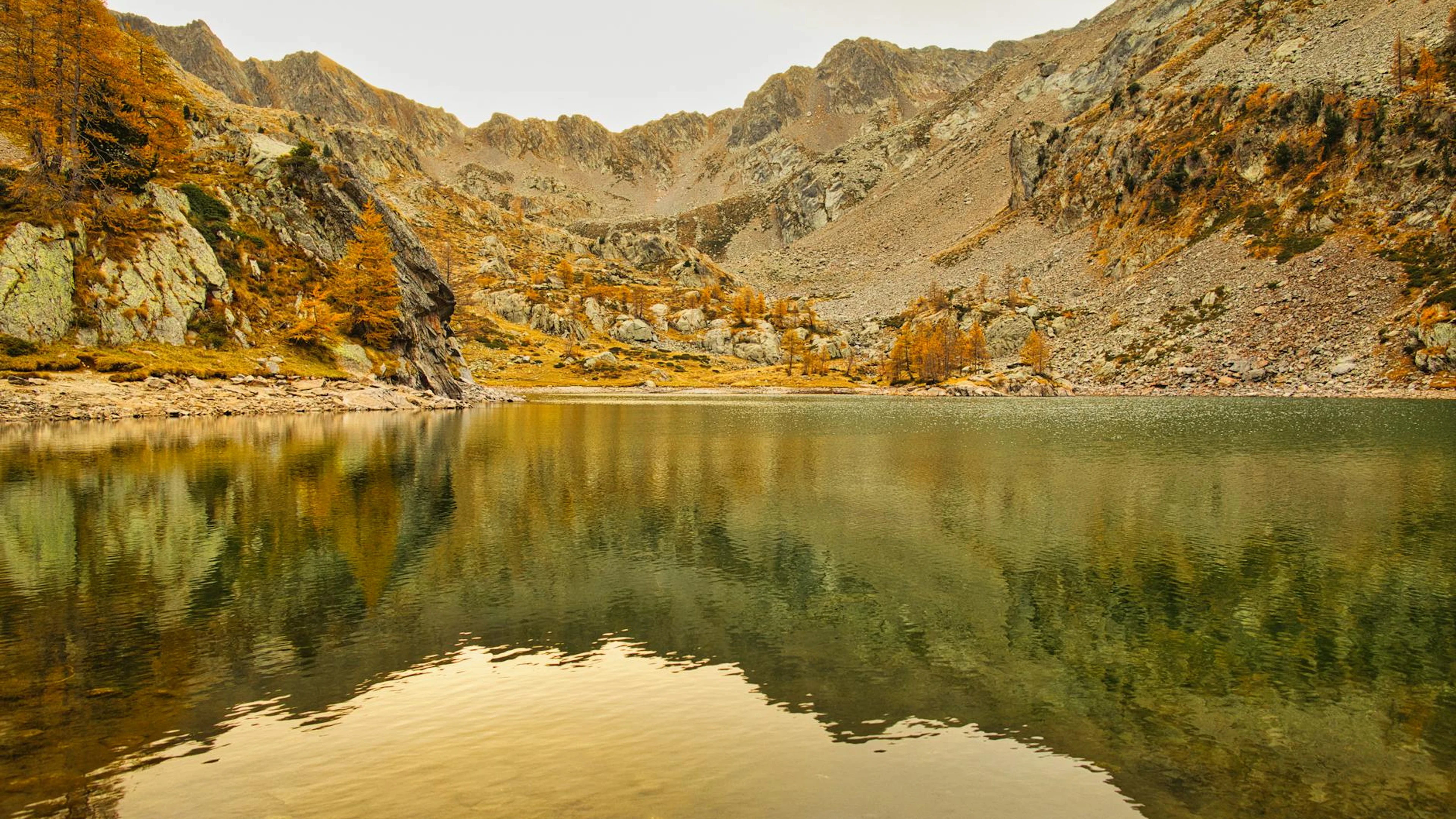 A tranquil autumn lake surrounded by mountains in Saint-Martin-Vésubie, France. - free 4K Ultra HD mountain wallpaper for desktop