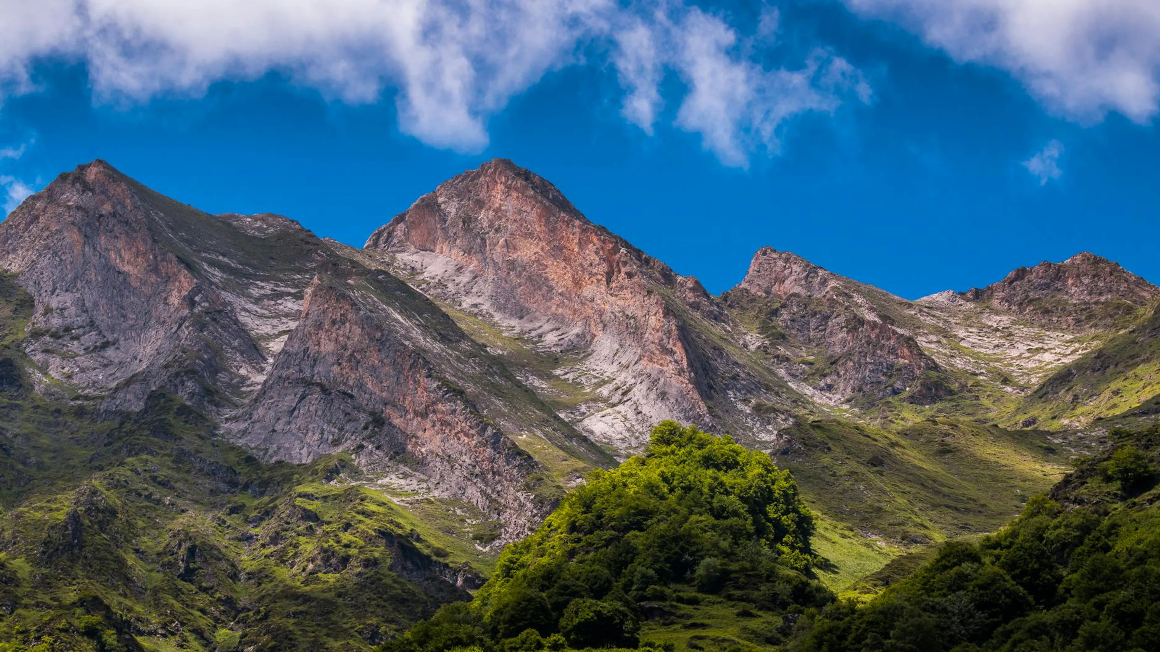 Breathtaking view of a mountain range in Occitanie, France under a vibrant blue - free 4K Ultra HD mountain wallpaper for desktop