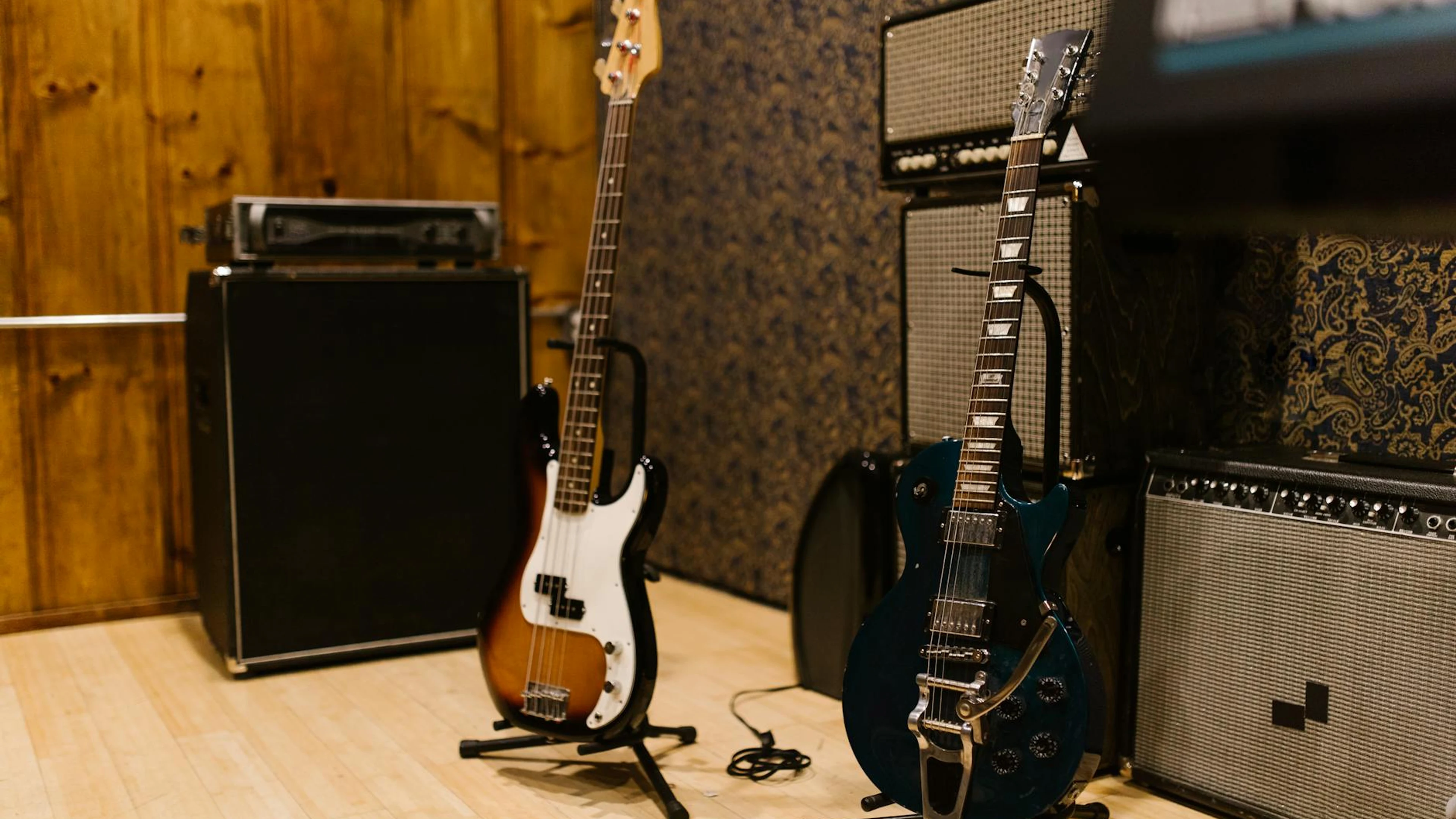 A cozy music studio featuring electric guitars and amplifiers, ideal for music p - free 4K Ultra HD music wallpaper for desktop