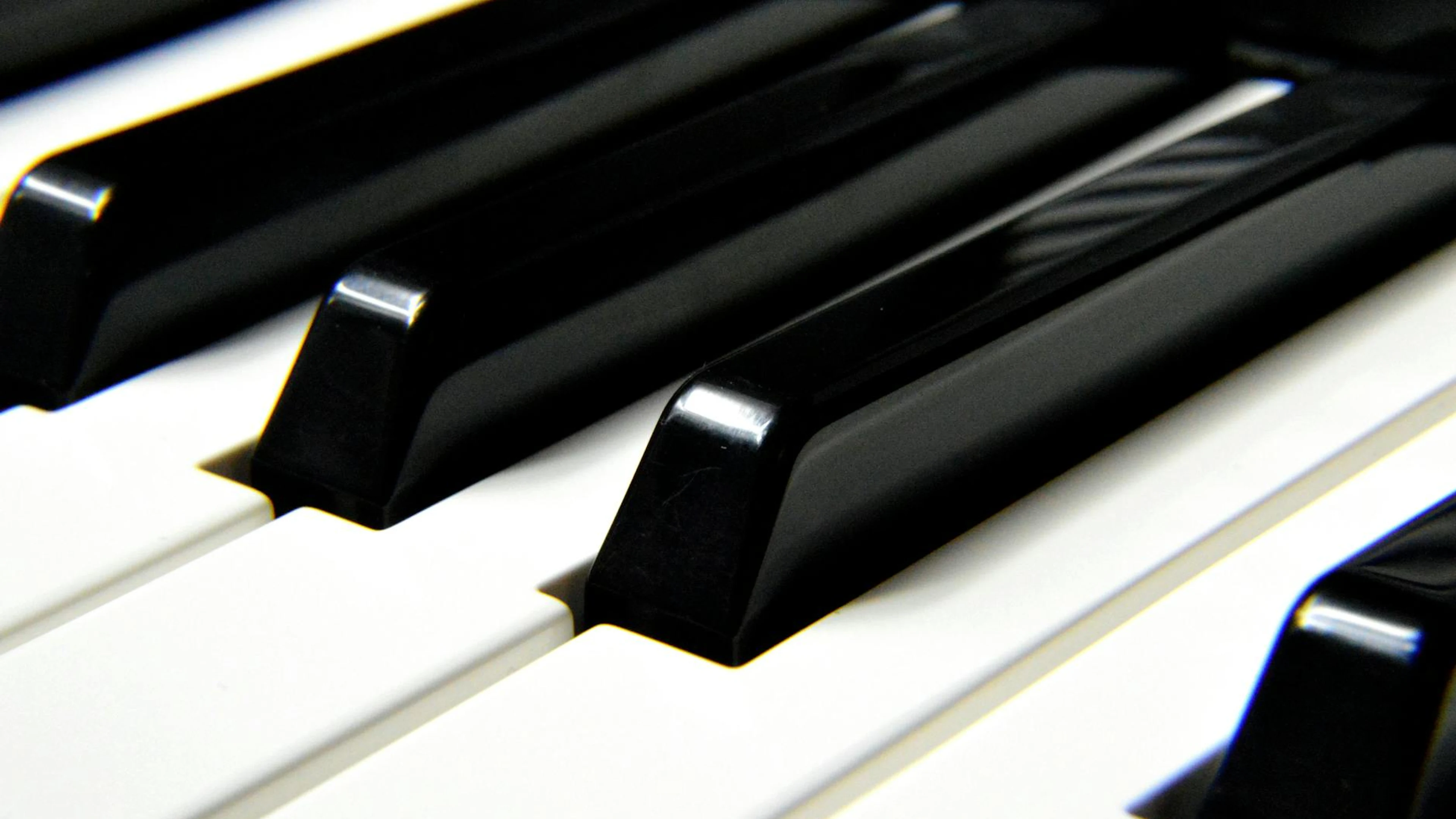 A detailed close-up shot focusing on black and white piano keys, highlighting mu - free 4K Ultra HD music wallpaper for desktop