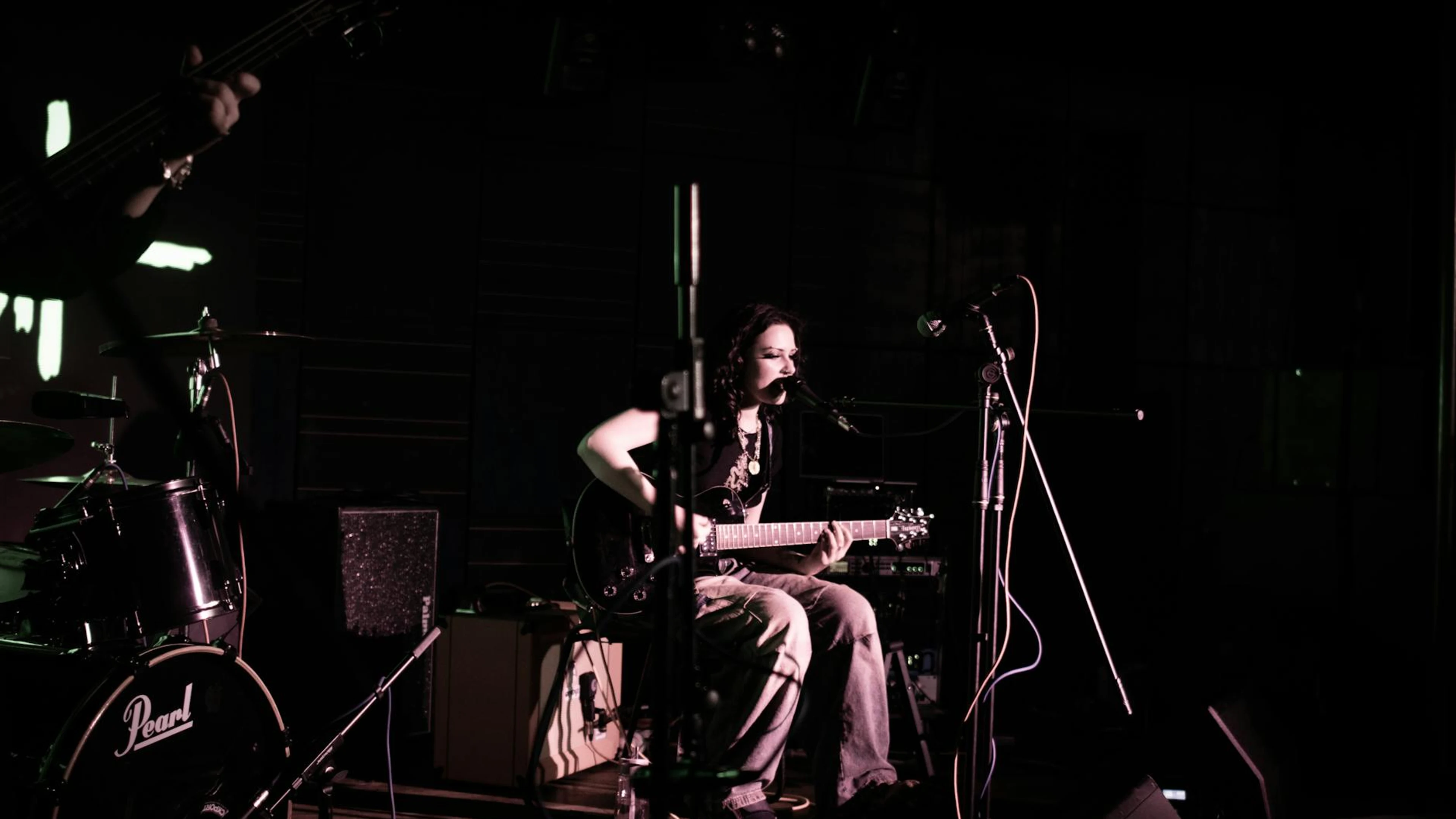 A female musician performing live with an electric guitar on stage. Concert atmo - free 4K Ultra HD music wallpaper for desktop