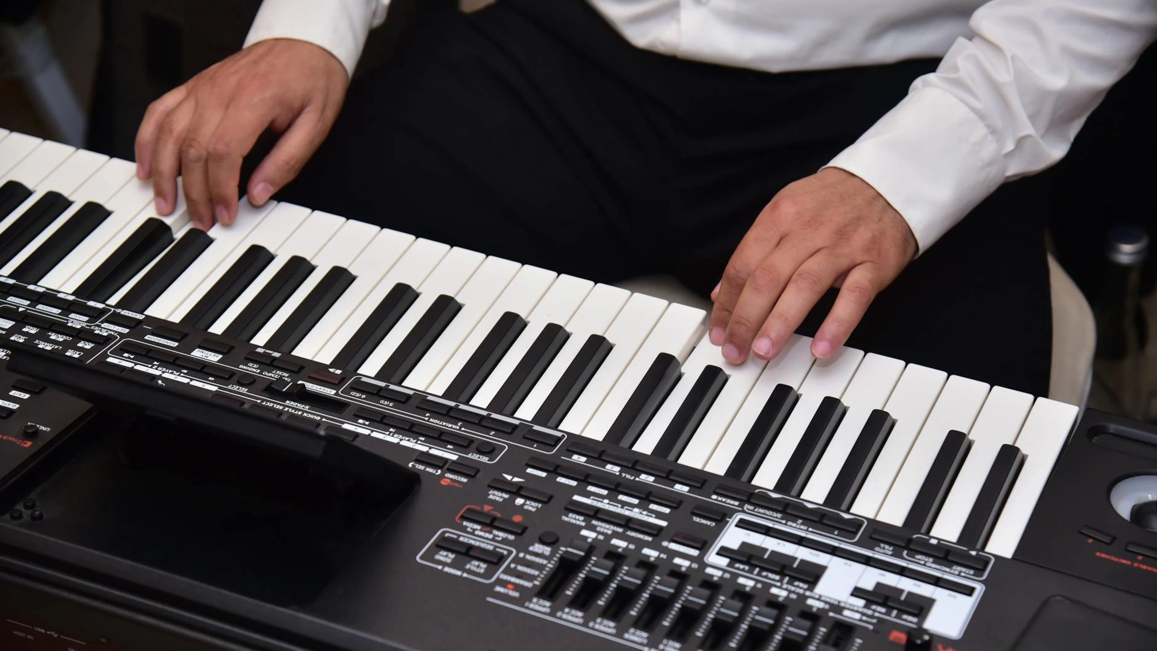 Close-up of a musician performing on a digital keyboard, showcasing skill and pr - free 4K Ultra HD music wallpaper for desktop