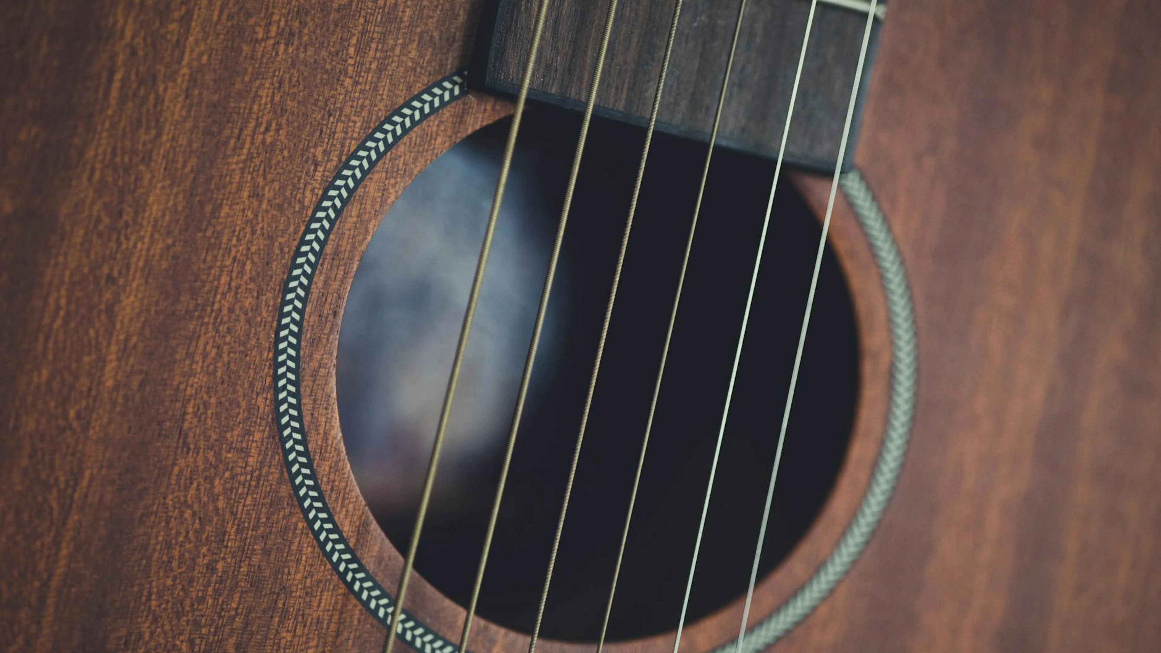 Detailed close-up of acoustic guitar strings and wood, highlighting musical inst - free 4K Ultra HD music wallpaper for desktop