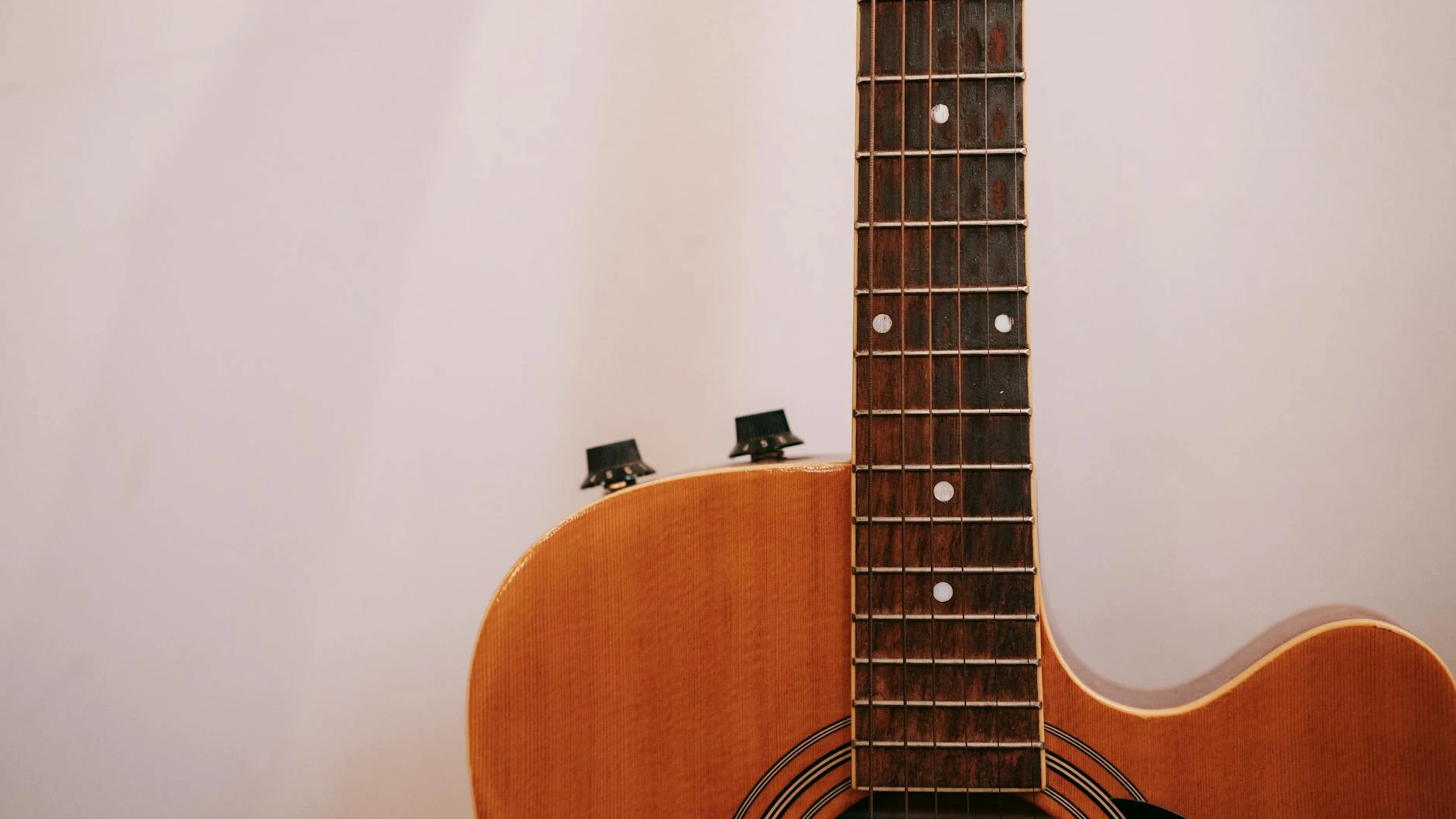 Detailed close-up of an acoustic guitar neck and body with strings visible again - free 4K Ultra HD music wallpaper for desktop