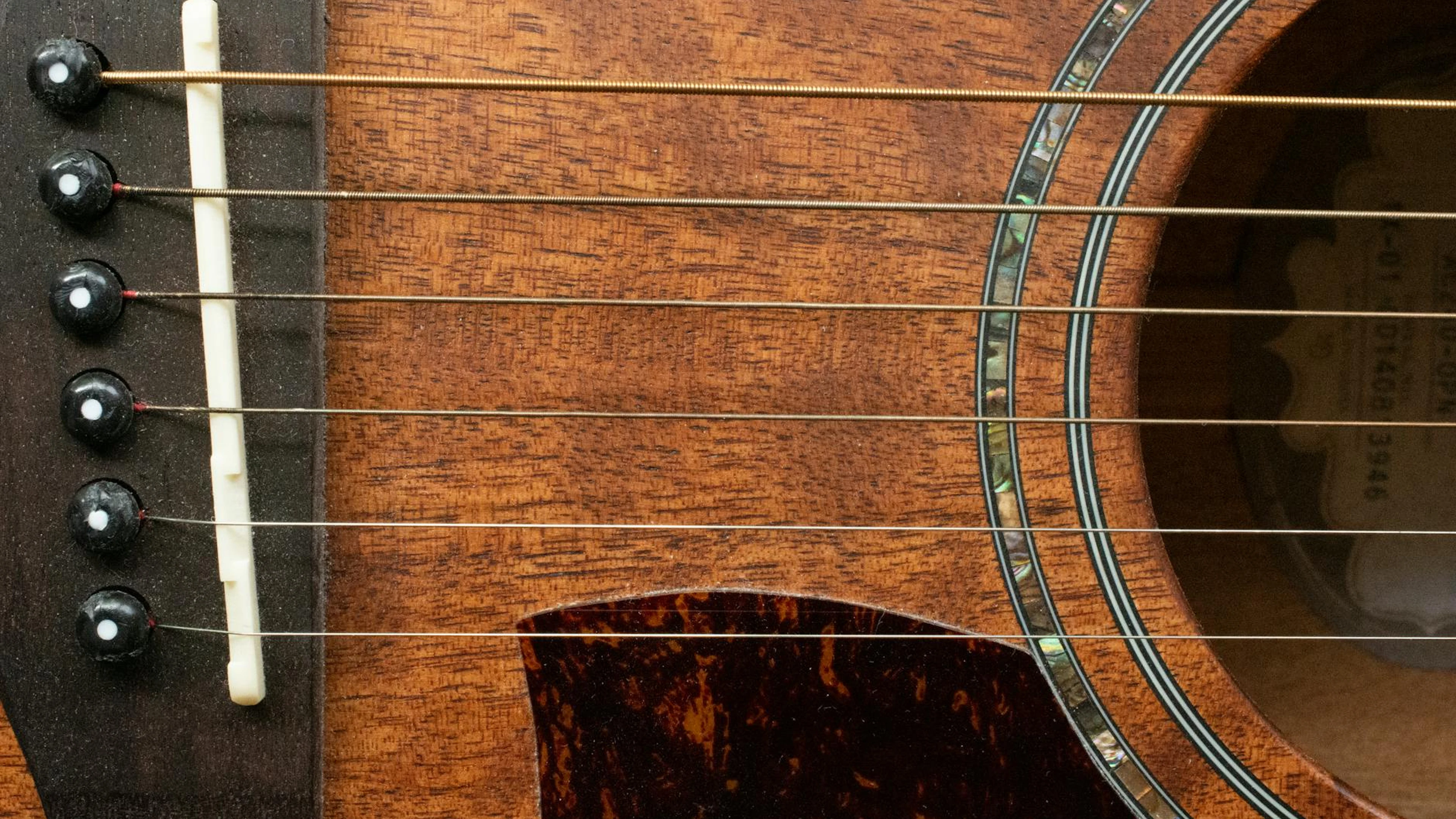 Detailed close-up of an acoustic guitar, showcasing strings and wood texture. - free 4K Ultra HD music wallpaper for desktop