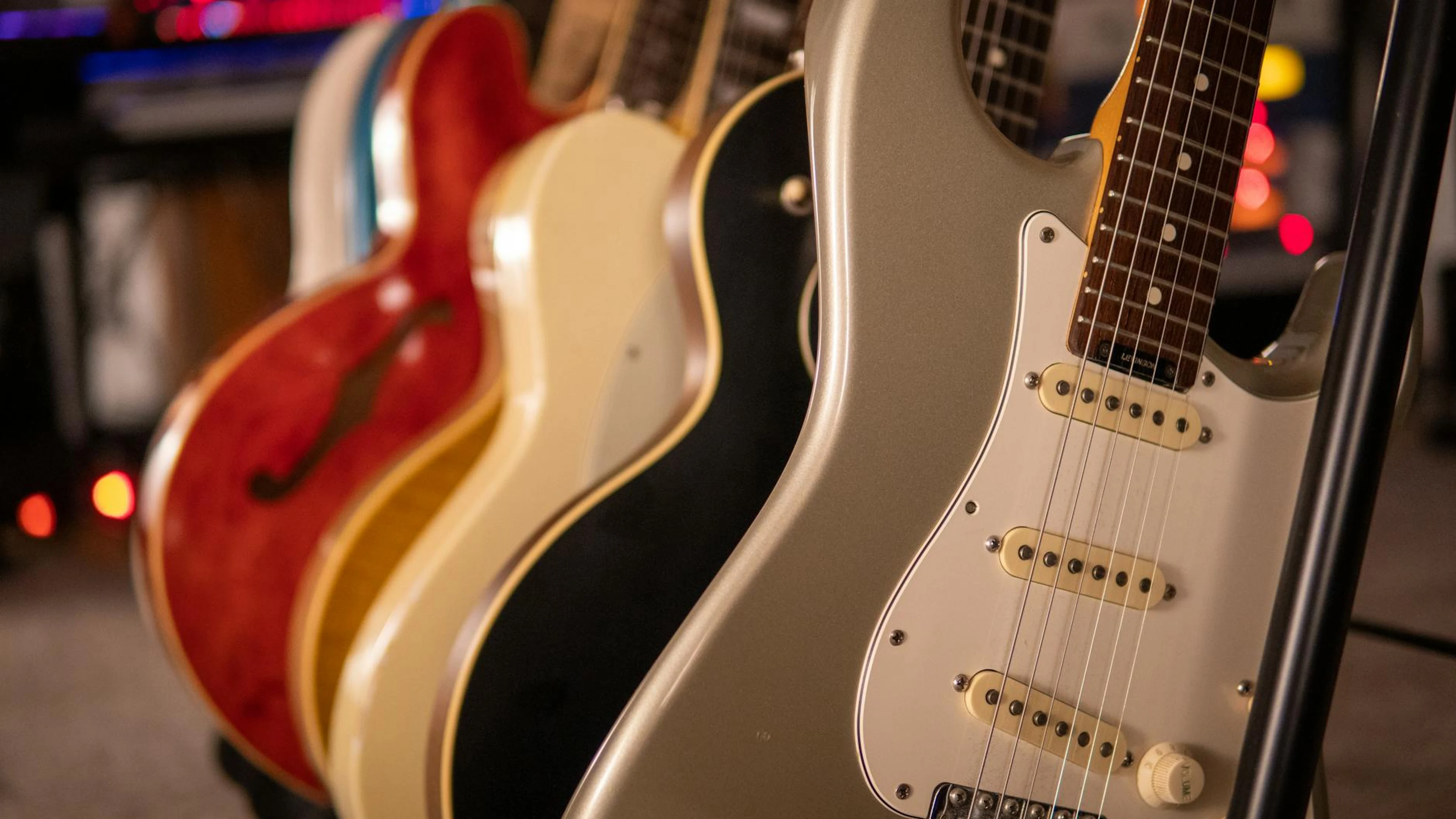 Row of electric guitars with a focus on elegant design and strings. - free 4K Ultra HD music wallpaper for desktop