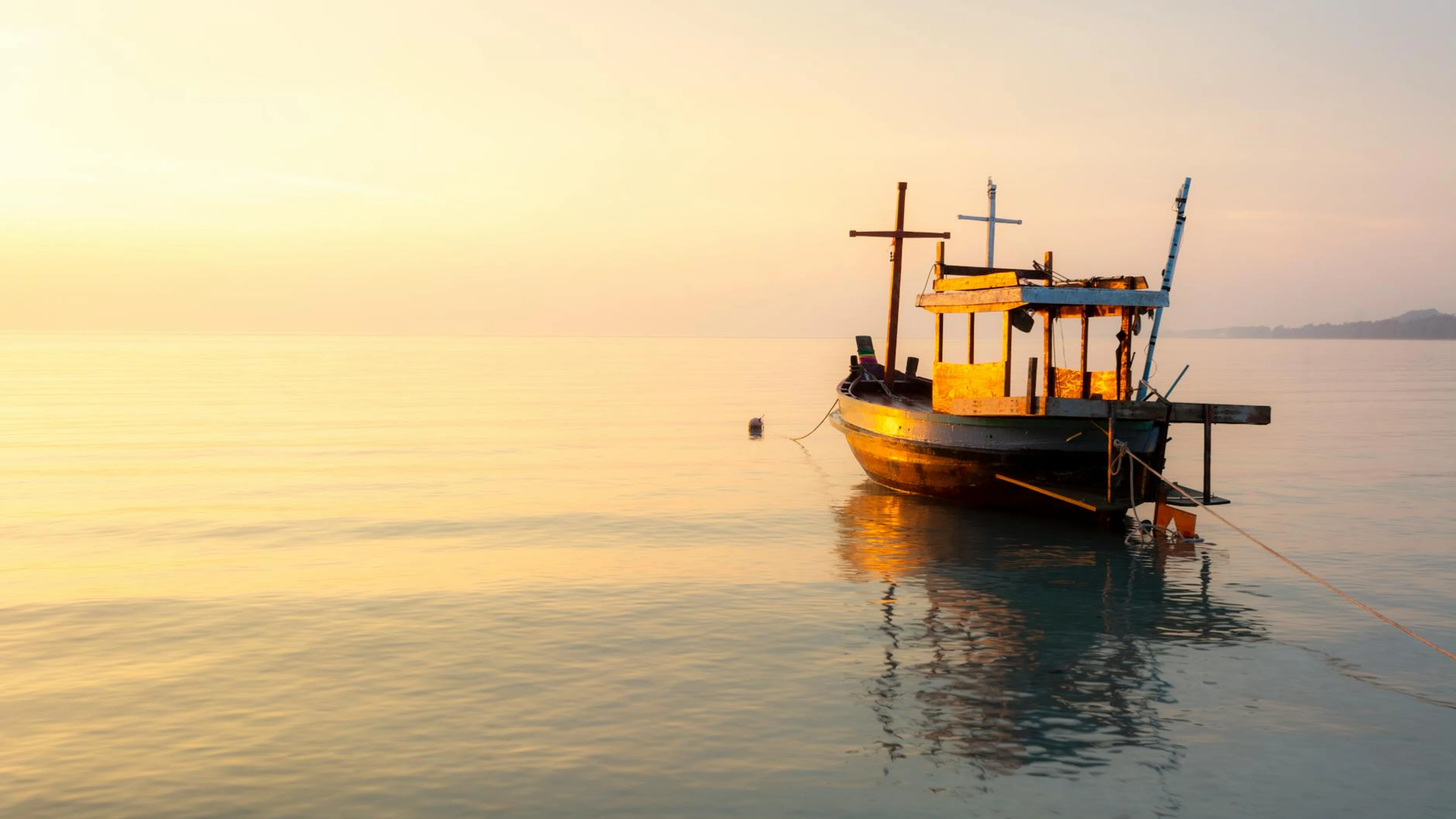 A peaceful scene of a moored wooden boat at sunset on calm ocean waters. - free 4K Ultra HD nature wallpaper for desktop